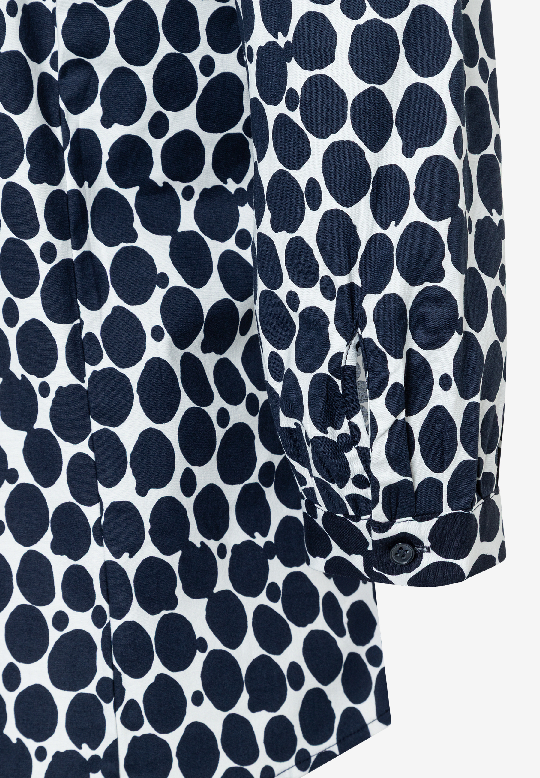 Nahaufnahme einer MORE & MORE Bluse mit blau-weißem Punktmuster und Knopfdetail am Ärmel. Nahaufnahme einer MORE & MORE Bluse mit blau-weißem Punktmuster und Knopfdetail am Ärmel.