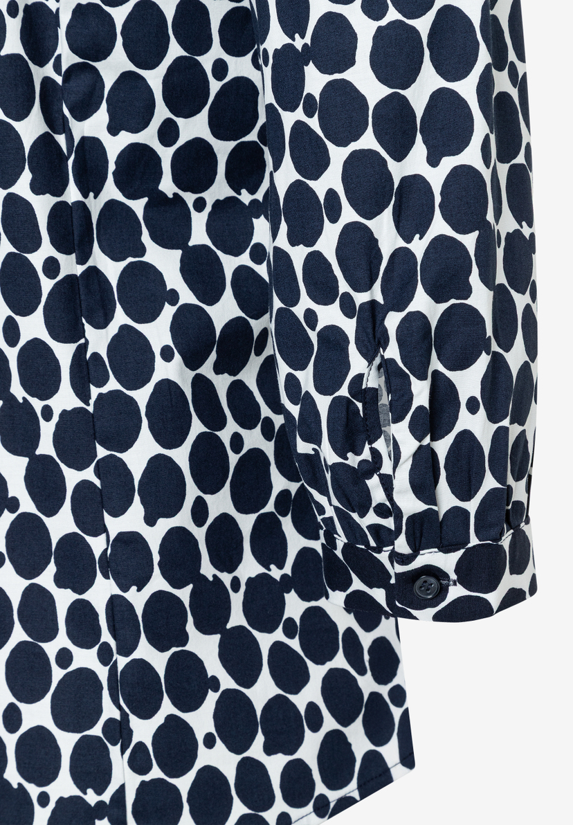 Nahaufnahme einer MORE & MORE Bluse mit blau-weißem Punktmuster und Knopfdetail am Ärmel. Nahaufnahme einer MORE & MORE Bluse mit blau-weißem Punktmuster und Knopfdetail am Ärmel.