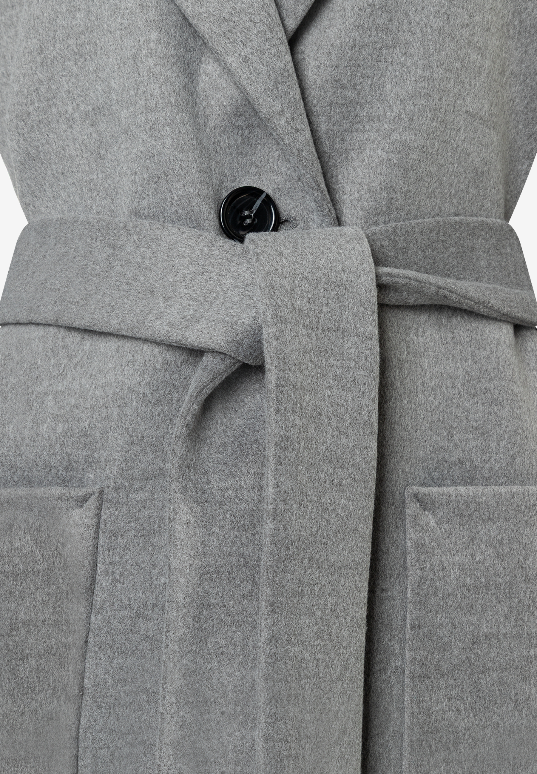 Nahaufnahme eines grauen MORE & MORE Oberteils mit Bindegürtel und Knopfdetail. Nahaufnahme eines grauen MORE & MORE Oberteils mit Bindegürtel und Knopfdetail.