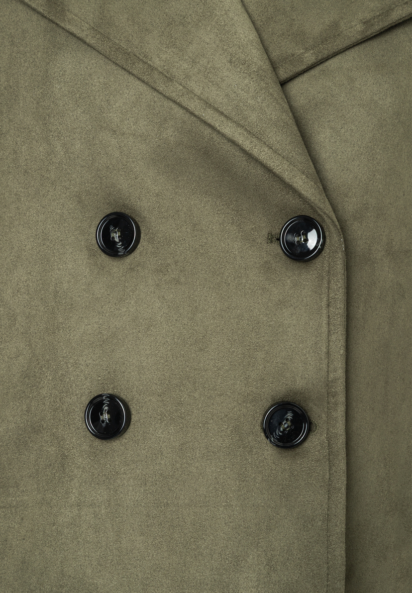 Nahaufnahme eines MORE & MORE Oberteils aus Kunstleder mit vier Knöpfen. Nahaufnahme eines MORE & MORE Oberteils aus Kunstleder mit vier Knöpfen.