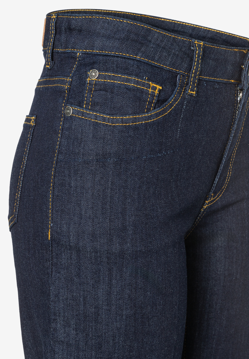 Nahaufnahme einer dunklen MORE & MORE Jeans mit gelben Nähten und einer kleinen Tasche am Bund. Nahaufnahme einer dunklen MORE & MORE Jeans mit gelben Nähten und einer kleinen Tasche am Bund.