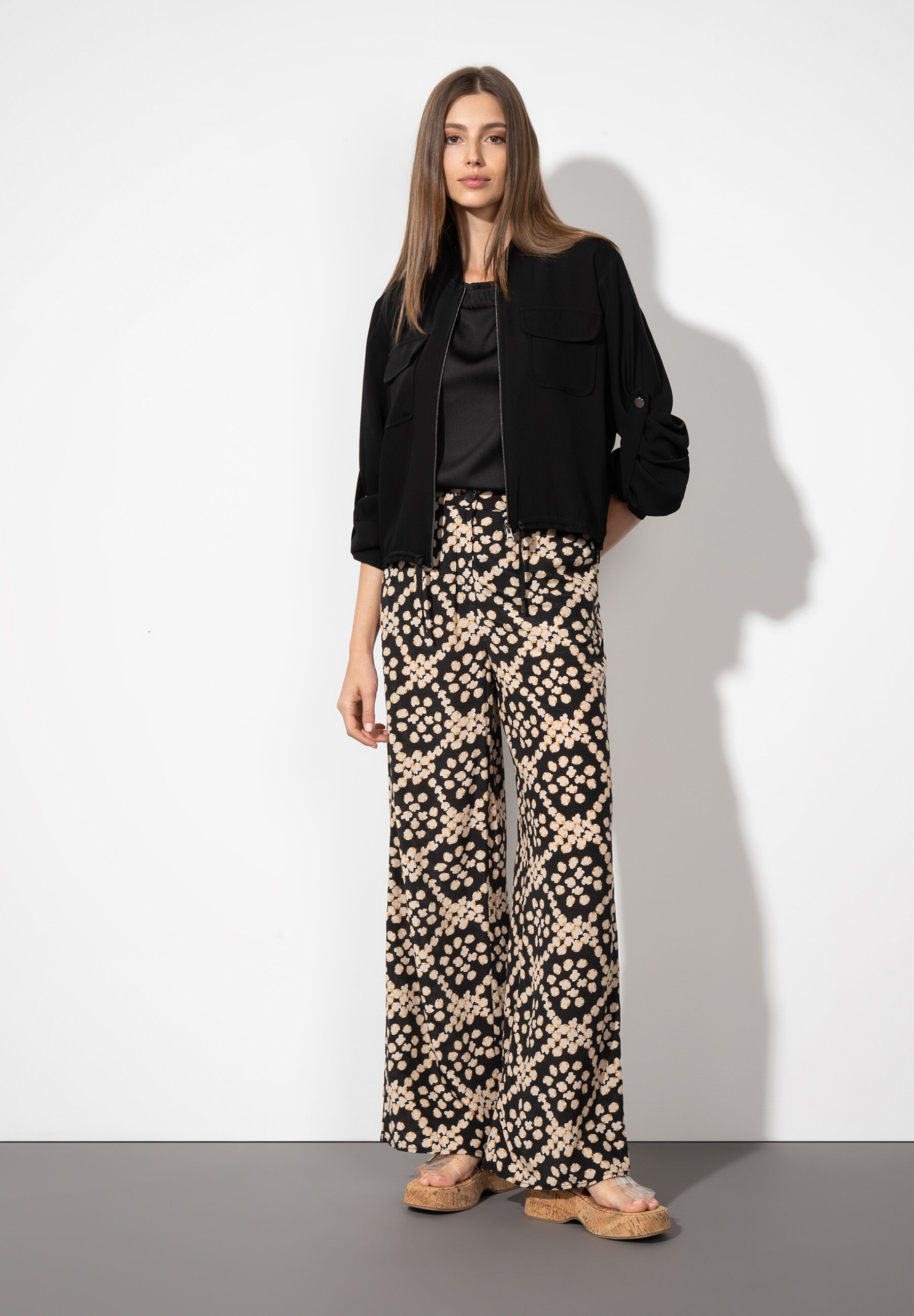 Eine Frau präsentiert MORE & MORE Webware-Hosen mit kühlendem Material und fließendem Fall vor einem hellen Hintergrund. Eine Frau präsentiert MORE & MORE Webware-Hosen mit kühlendem Material und fließendem Fall vor einem hellen Hintergrund.