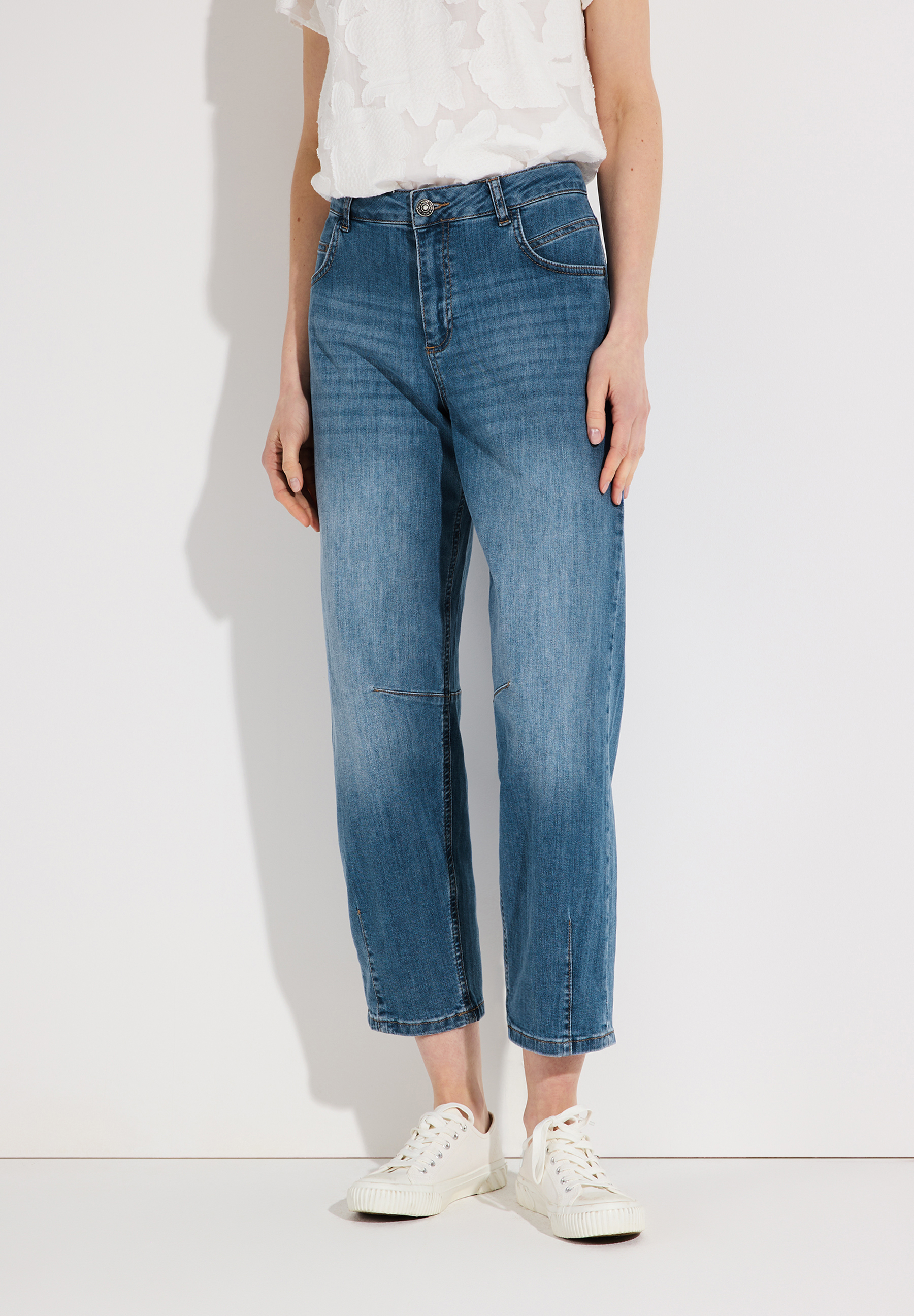 Eine Frau mit MORE & MORE Jeanshose aus Denim-Material mit angenehmem Tragekomfort. Die Hose ist elastisch und blau.