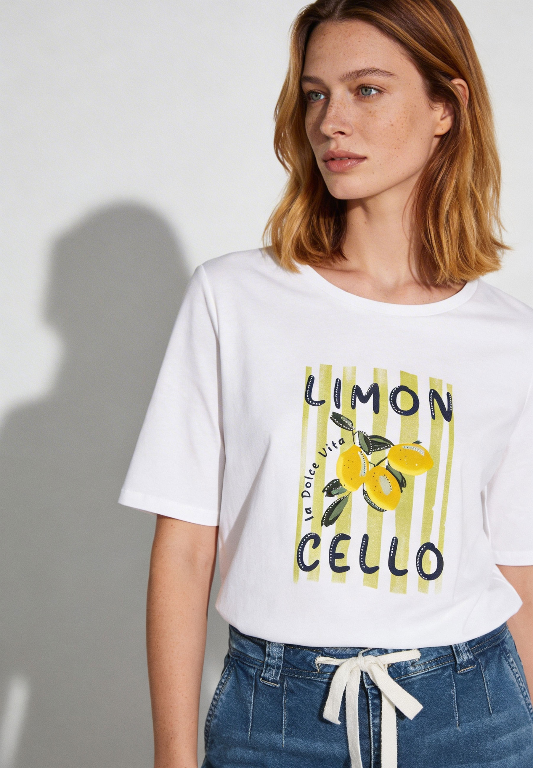Ein weißes MORE & MORE T-Shirt mit "Limoncello"-Aufdruck und Zitronenmotiv. Ein weißes MORE & MORE T-Shirt mit "Limoncello"-Aufdruck und Zitronenmotiv.