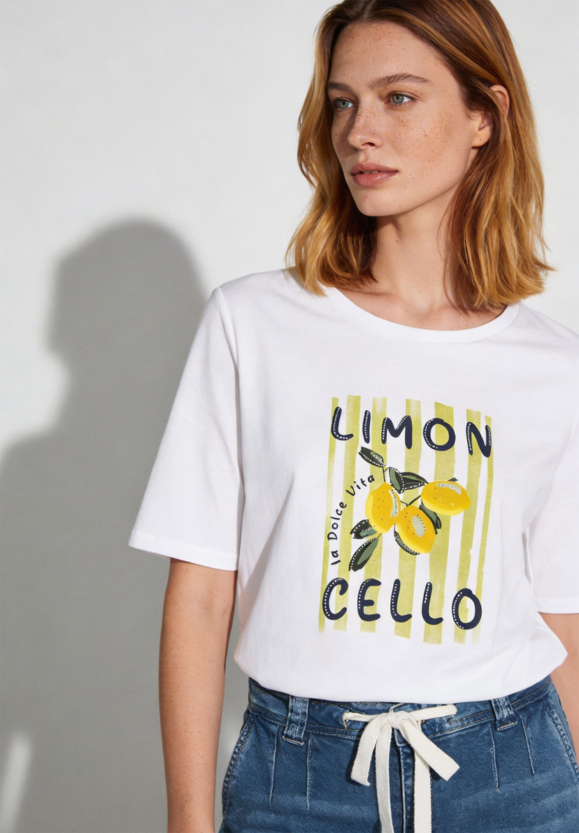 Ein weißes MORE & MORE T-Shirt mit "Limoncello"-Aufdruck und Zitronenmotiv. Ein weißes MORE & MORE T-Shirt mit "Limoncello"-Aufdruck und Zitronenmotiv.