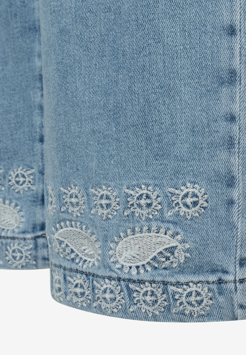 Detailansicht einer MORE & MORE Jeans mit dekorativer, weißer Saumbordüre. Detailansicht einer MORE & MORE Jeans mit dekorativer, weißer Saumbordüre.