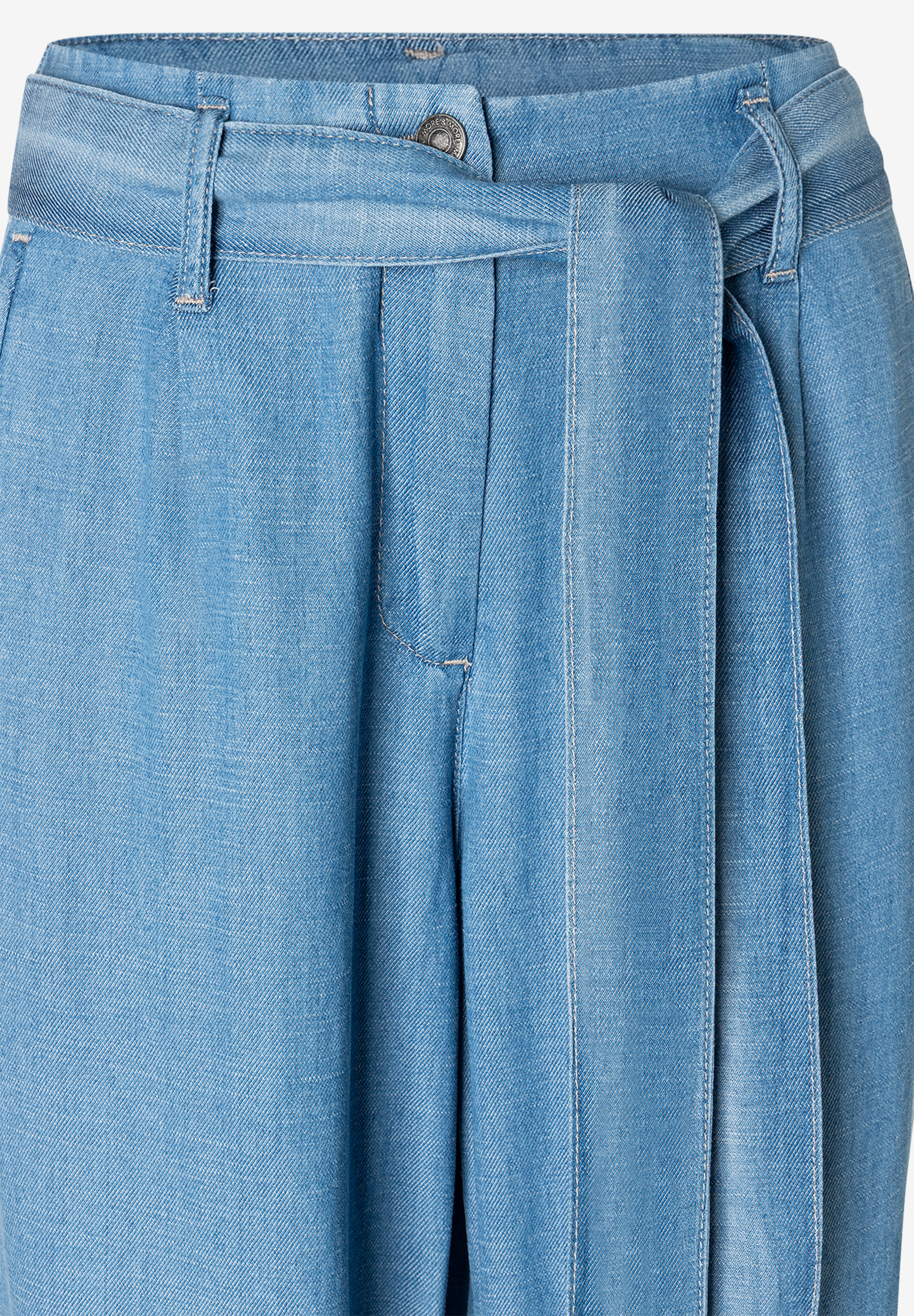 Nahaufnahme einer hellblauen MORE & MORE Hose mit Denim-Bindegürtel. Nahaufnahme einer hellblauen MORE & MORE Hose mit Denim-Bindegürtel.