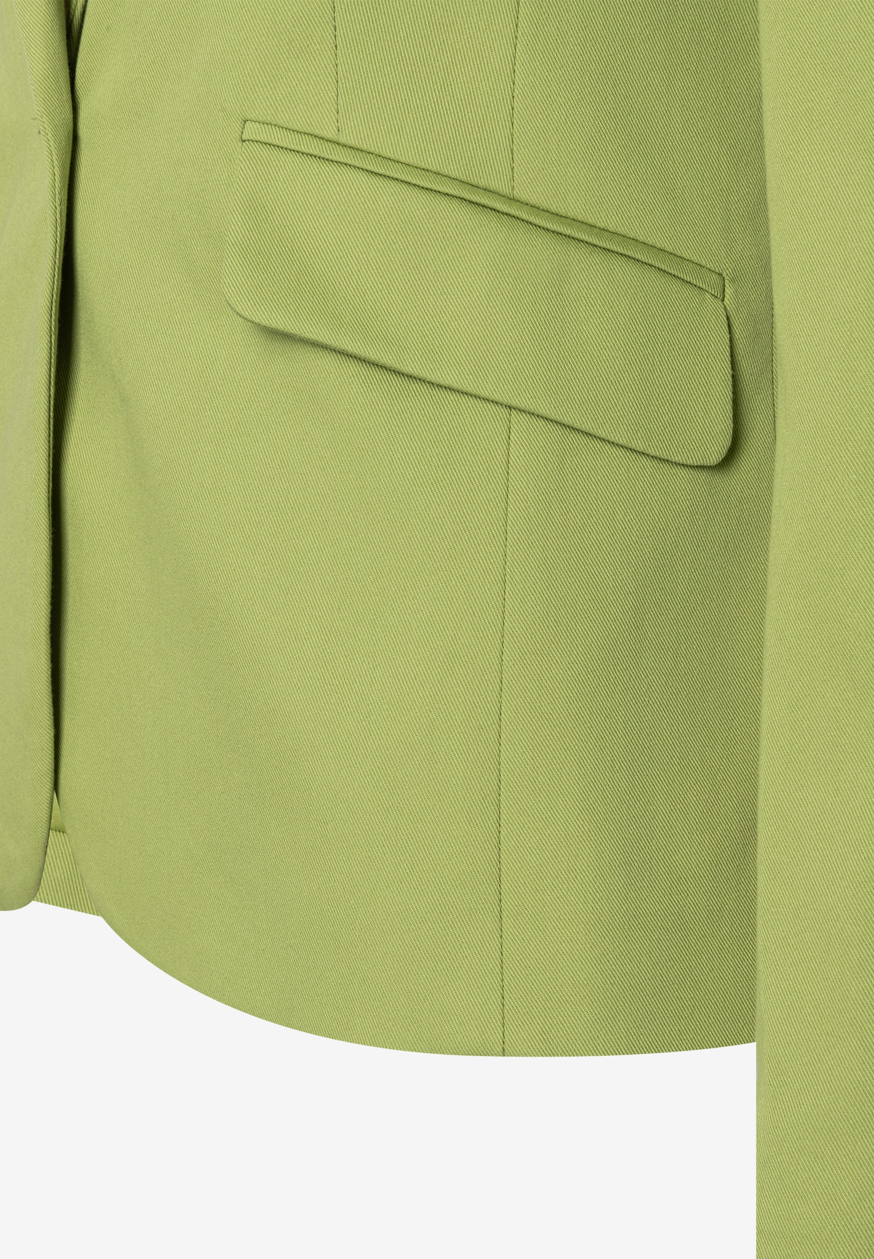 Nahaufnahme eines grünen MORE & MORE Blazers mit angedeuteter Tasche und Ärmeldetail. Nahaufnahme eines grünen MORE & MORE Blazers mit angedeuteter Tasche und Ärmeldetail.