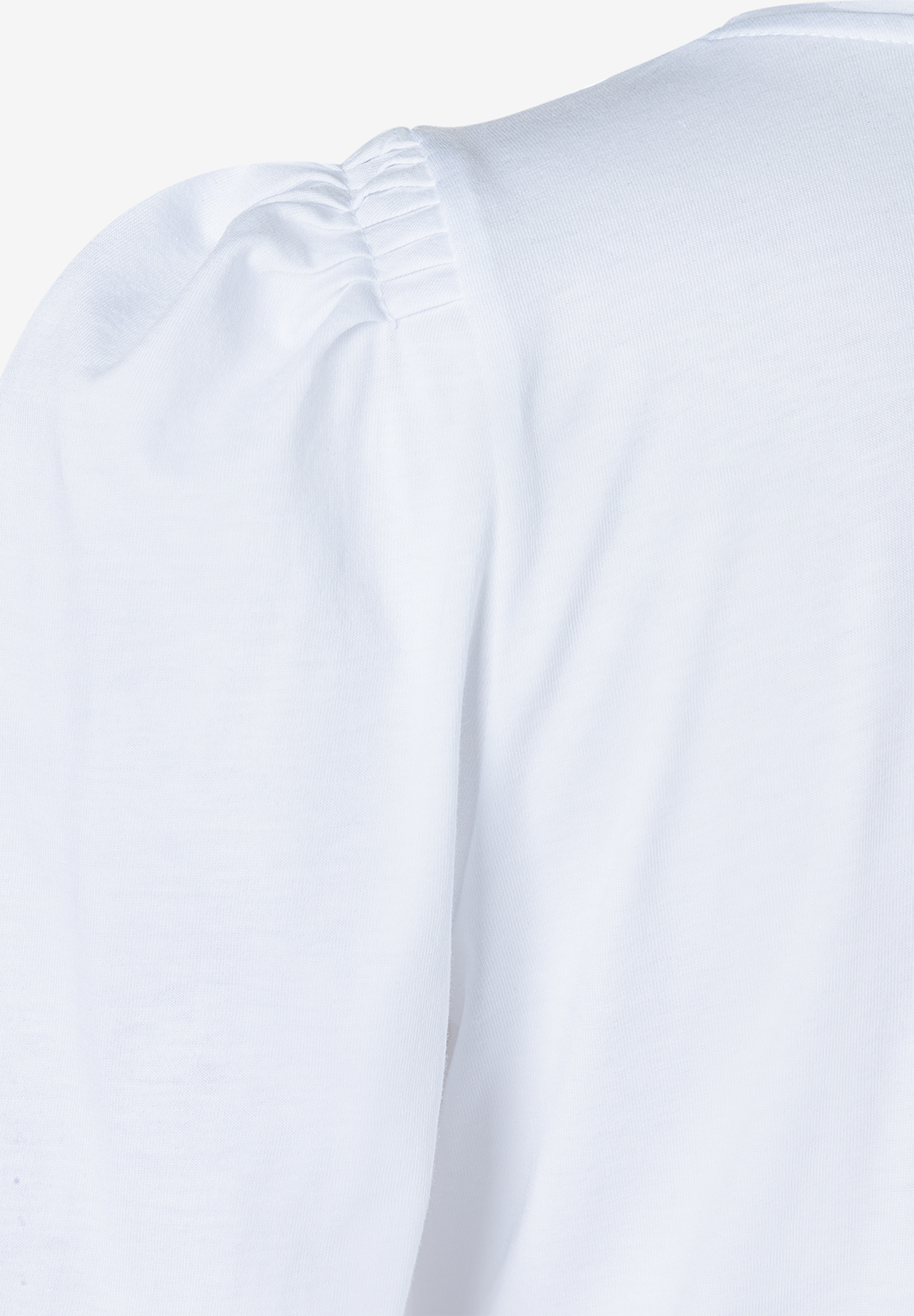 Detailaufnahme eines weißen Jersey-Oberteils von MORE & MORE mit geraffter Puffärmel.