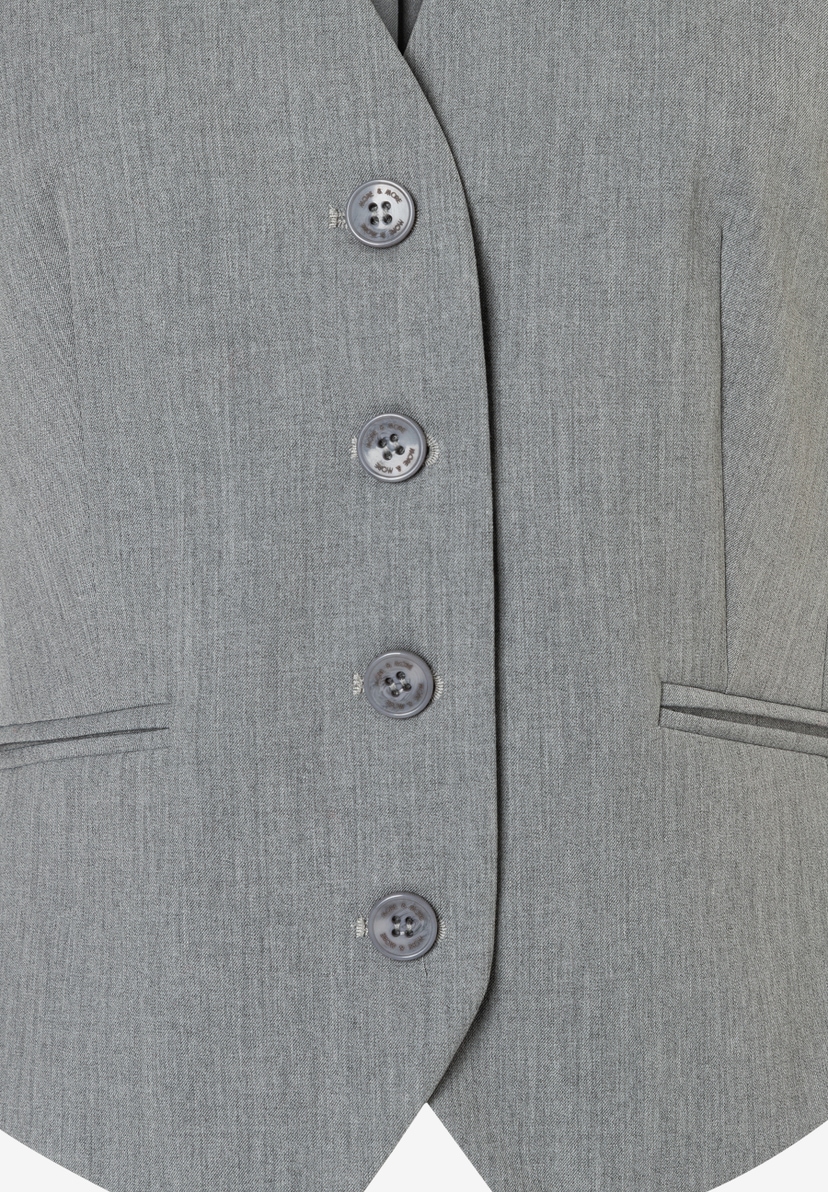 Nahaufnahme eines grauen Blazers von MORE & MORE mit Knöpfen und Taschen-Details. Nahaufnahme eines grauen Blazers von MORE & MORE mit Knöpfen und Taschen-Details.