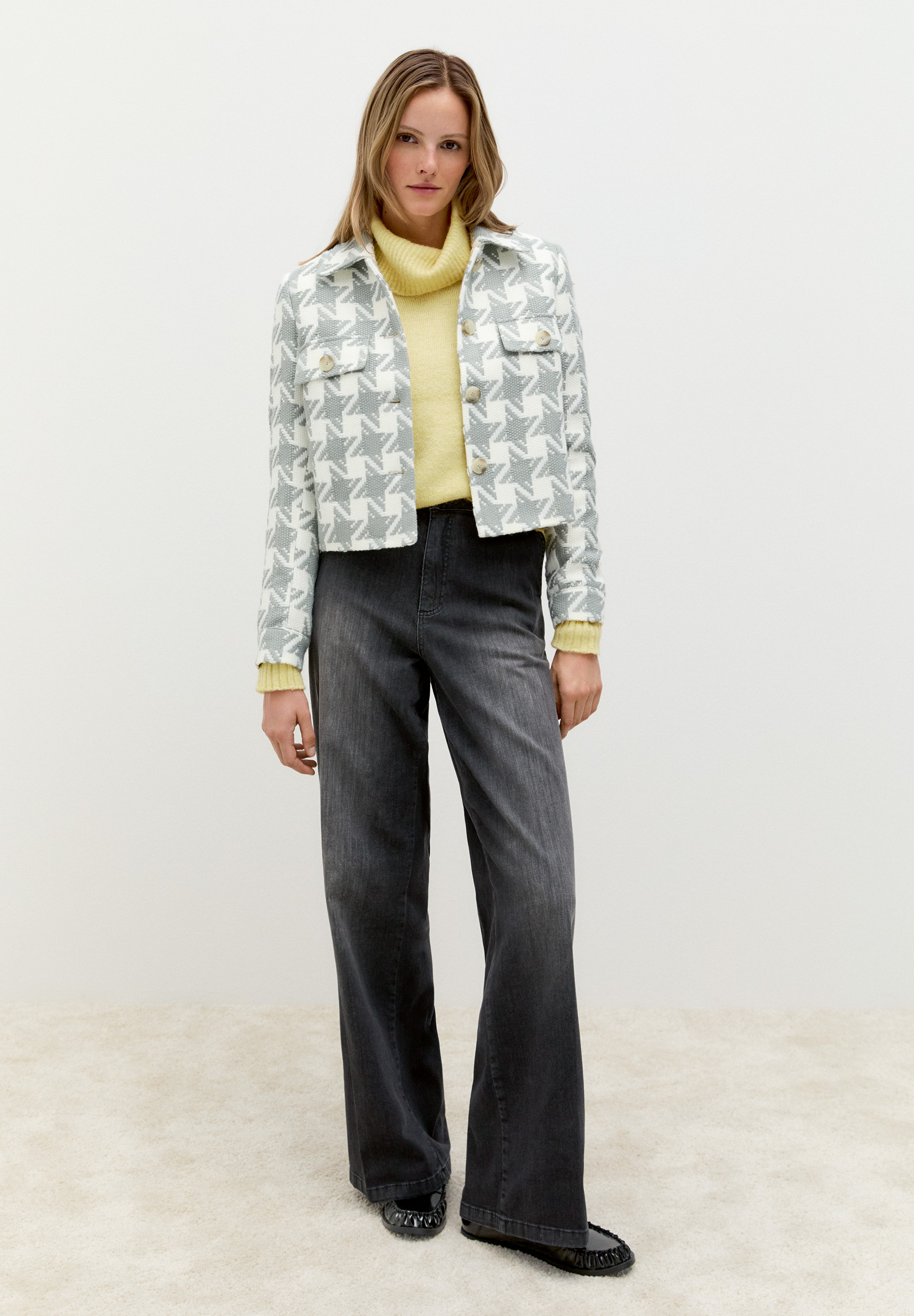 Eine Frau trägt einen MORE & MORE Blazer mit Sternmuster, kombiniert mit Jeans und einem gelben Rollkragenpullover. Eine Frau trägt einen MORE & MORE Blazer mit Sternmuster, kombiniert mit Jeans und einem gelben Rollkragenpullover.