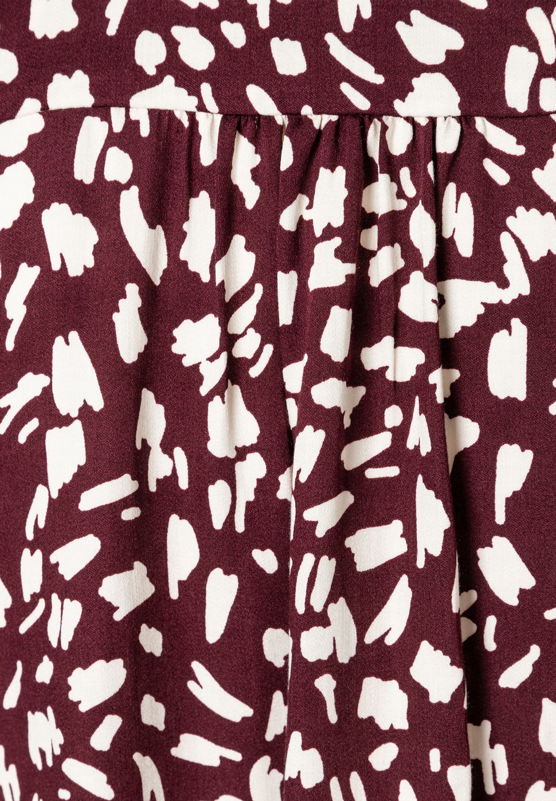 MORE & MORE Bluse: Bordeauxroter Stoff mit unregelmäßigen weißen Flecken, leichter Faltenwurf. MORE & MORE Bluse: Bordeauxroter Stoff mit unregelmäßigen weißen Flecken, leichter Faltenwurf.