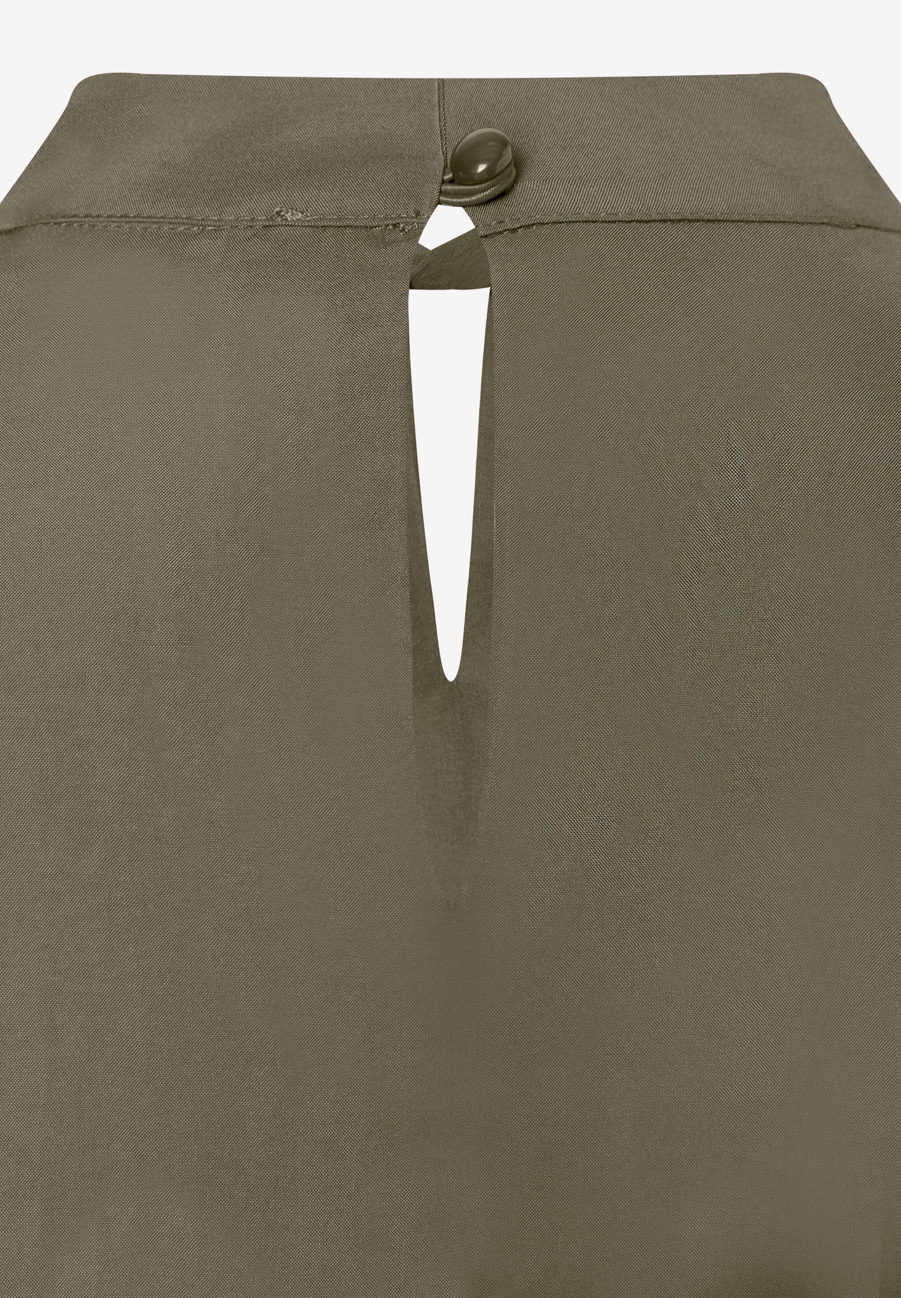 MORE & MORE Bluse: Detailaufnahme des Nackenschlitzes mit einem dunkelgrünen Knopf. MORE & MORE Bluse: Detailaufnahme des Nackenschlitzes mit einem dunkelgrünen Knopf.