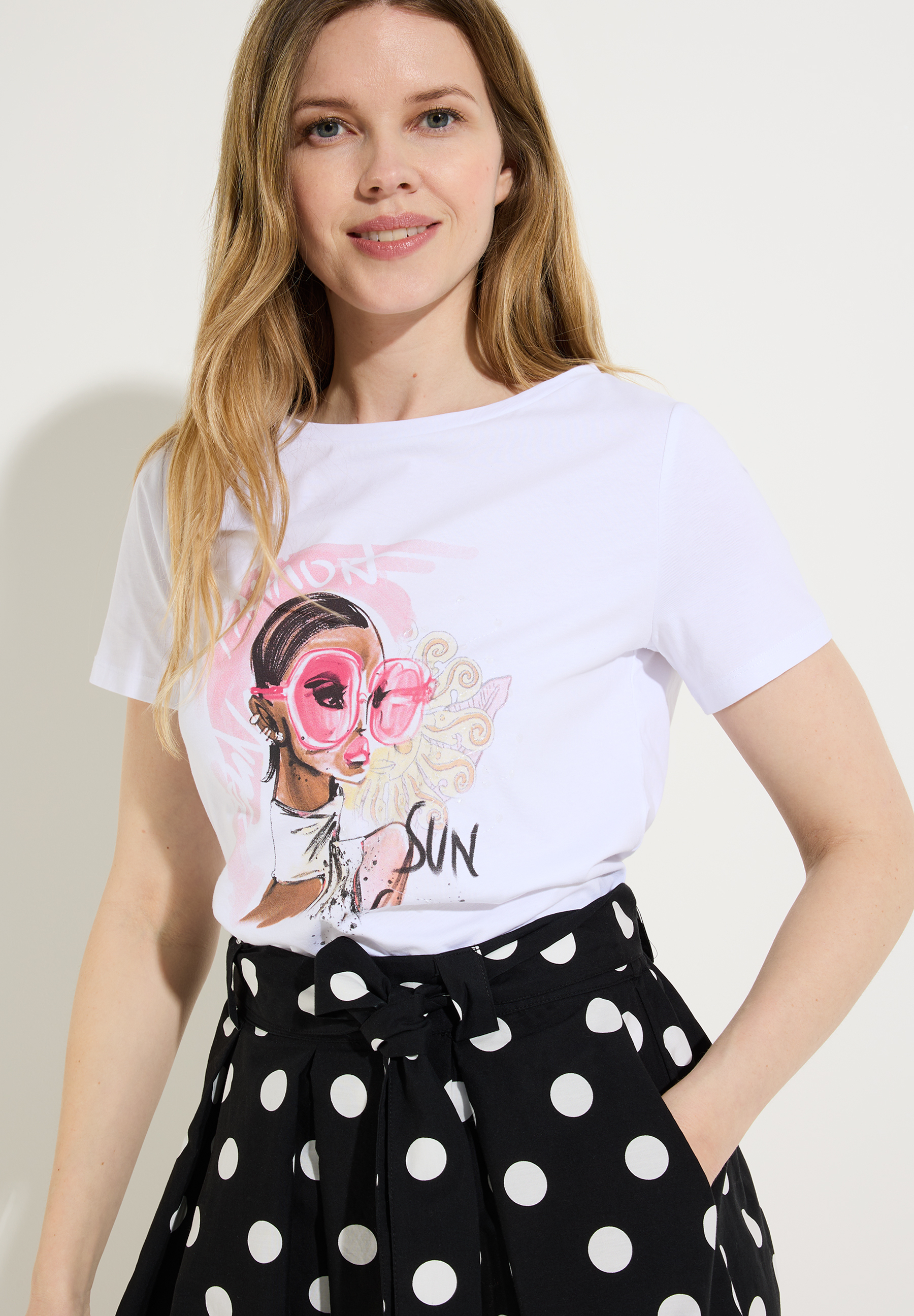 Eine Frau in einem MORE & MORE Oberteil mit Print-Motiv. Der Jersey sorgt für angenehmen Tragekomfort. Eine Frau in einem MORE & MORE Oberteil mit Print-Motiv. Der Jersey sorgt für angenehmen Tragekomfort.