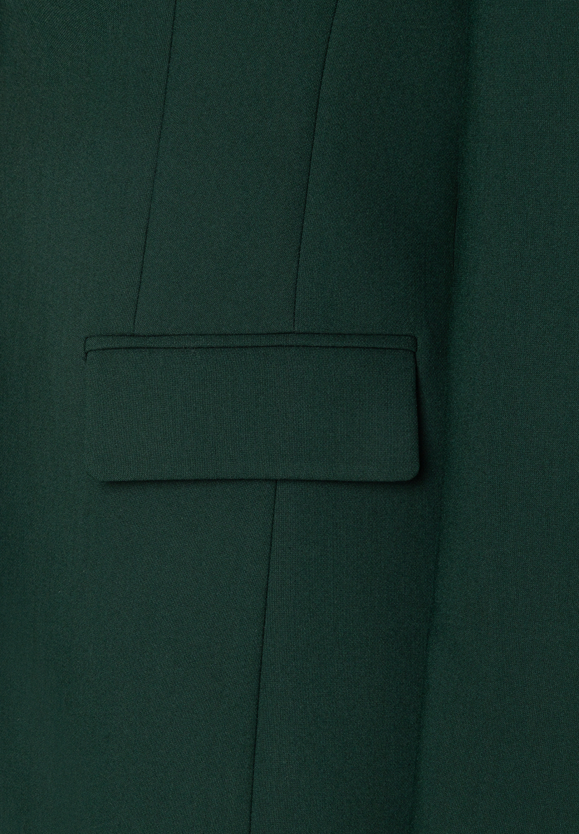 Detailansicht des MORE & MORE Blazers in Tannengrün, mit einer eleganten Pattentasche. Der Stoff zeigt eine feine Textur und klare Nähte.