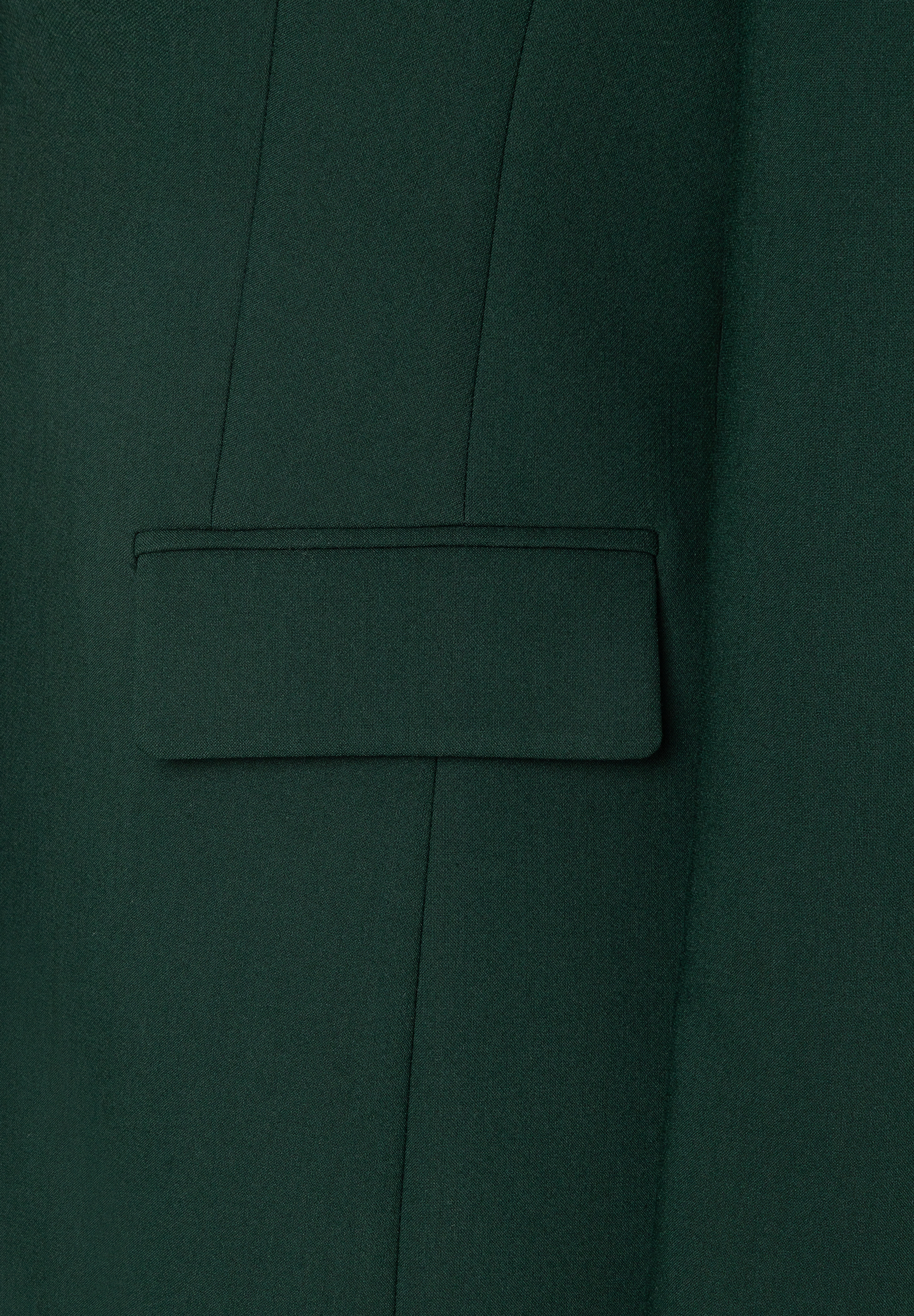 Detailansicht des MORE & MORE Blazers in Tannengrün, mit einer eleganten Pattentasche. Der Stoff zeigt eine feine Textur und klare Nähte. Detailansicht des MORE & MORE Blazers in Tannengrün, mit einer eleganten Pattentasche. Der Stoff zeigt eine feine Textur und klare Nähte.