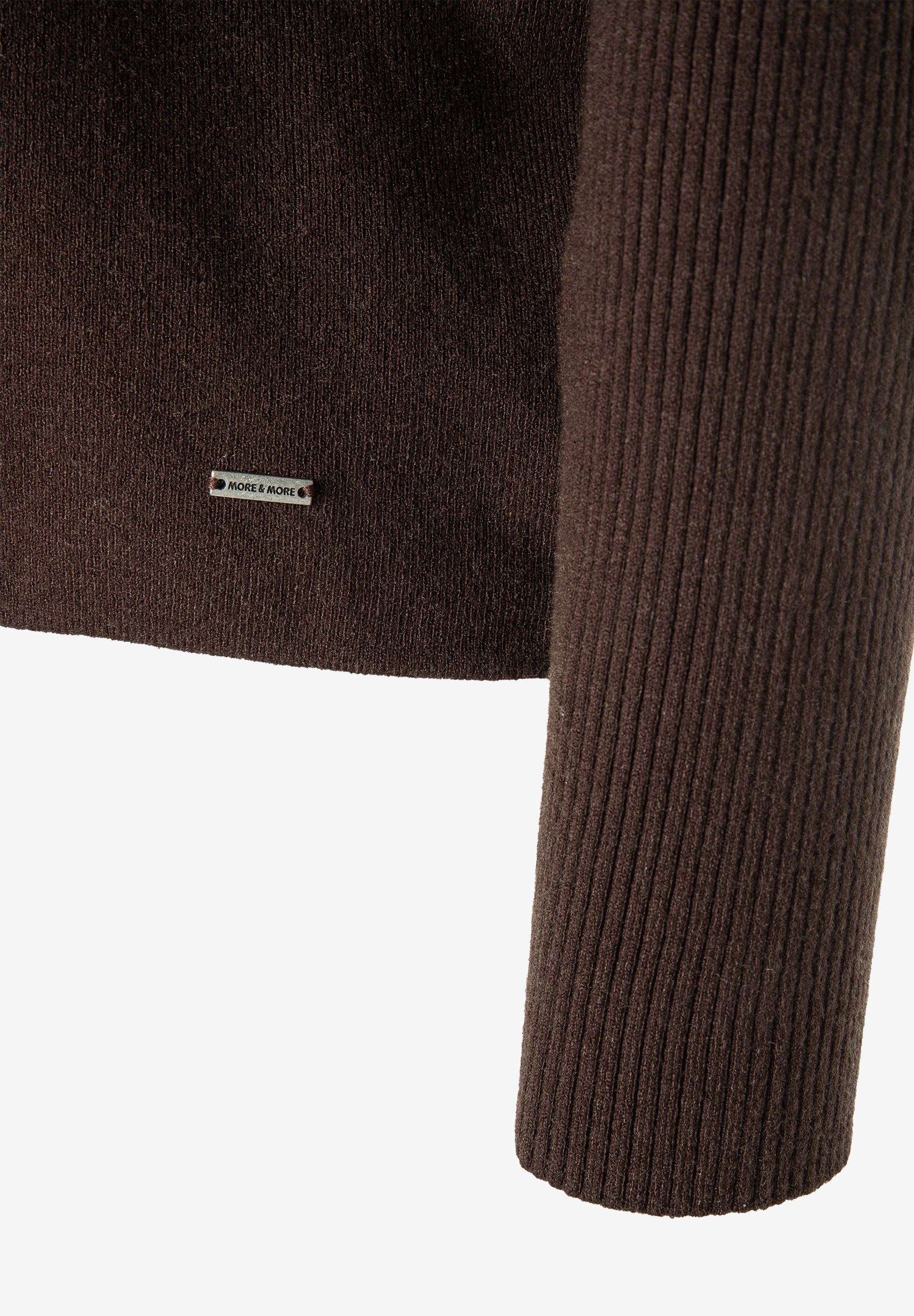MORE & MORE Pullover: Detail eines braunen Strickpullovers mit Rippstrick-Ärmel und kleinem Markenlabel am Saum. MORE & MORE Pullover: Detail eines braunen Strickpullovers mit Rippstrick-Ärmel und kleinem Markenlabel am Saum.