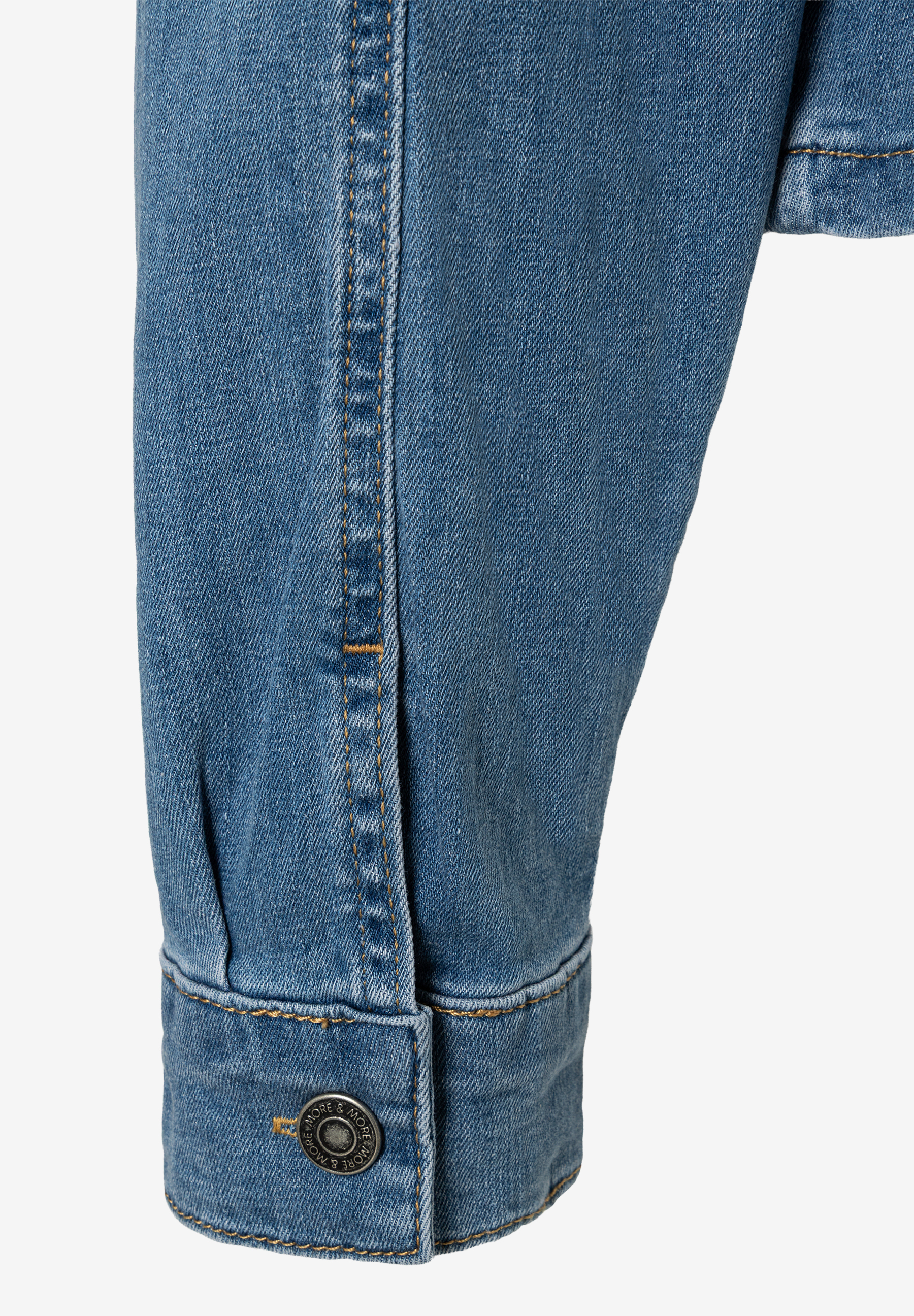Detailansicht einer MORE & MORE Jeansjacke, Fokus auf Ärmel und Knopf. Detailansicht einer MORE & MORE Jeansjacke, Fokus auf Ärmel und Knopf.