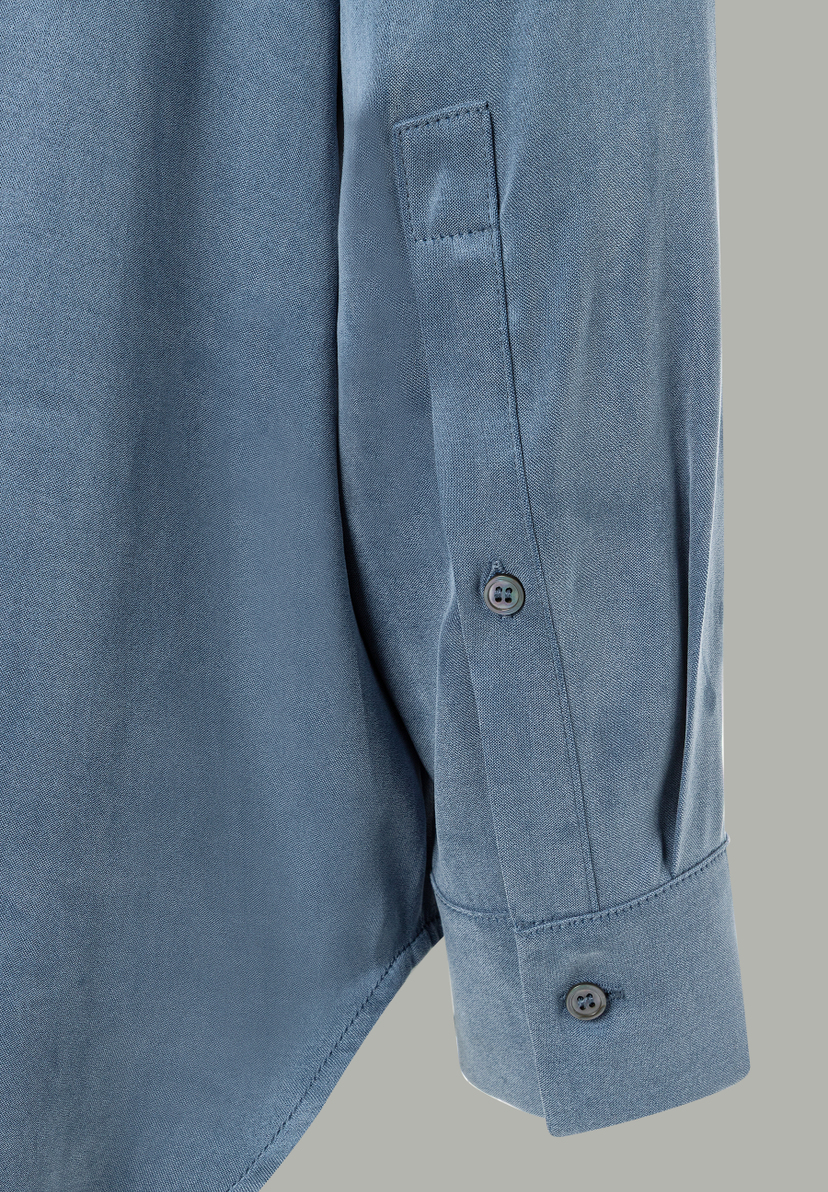 Nahaufnahme vom Ärmel einer blauen MORE & MORE Bluse mit Knopfmanschette. Nahaufnahme vom Ärmel einer blauen MORE & MORE Bluse mit Knopfmanschette.