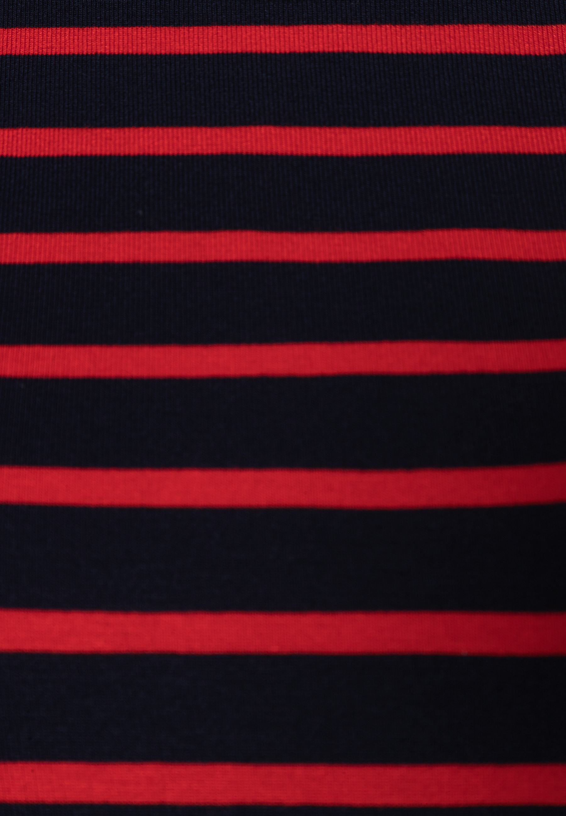 Detailansicht eines MORE & MORE Oberteils, rot-schwarz gestreift.