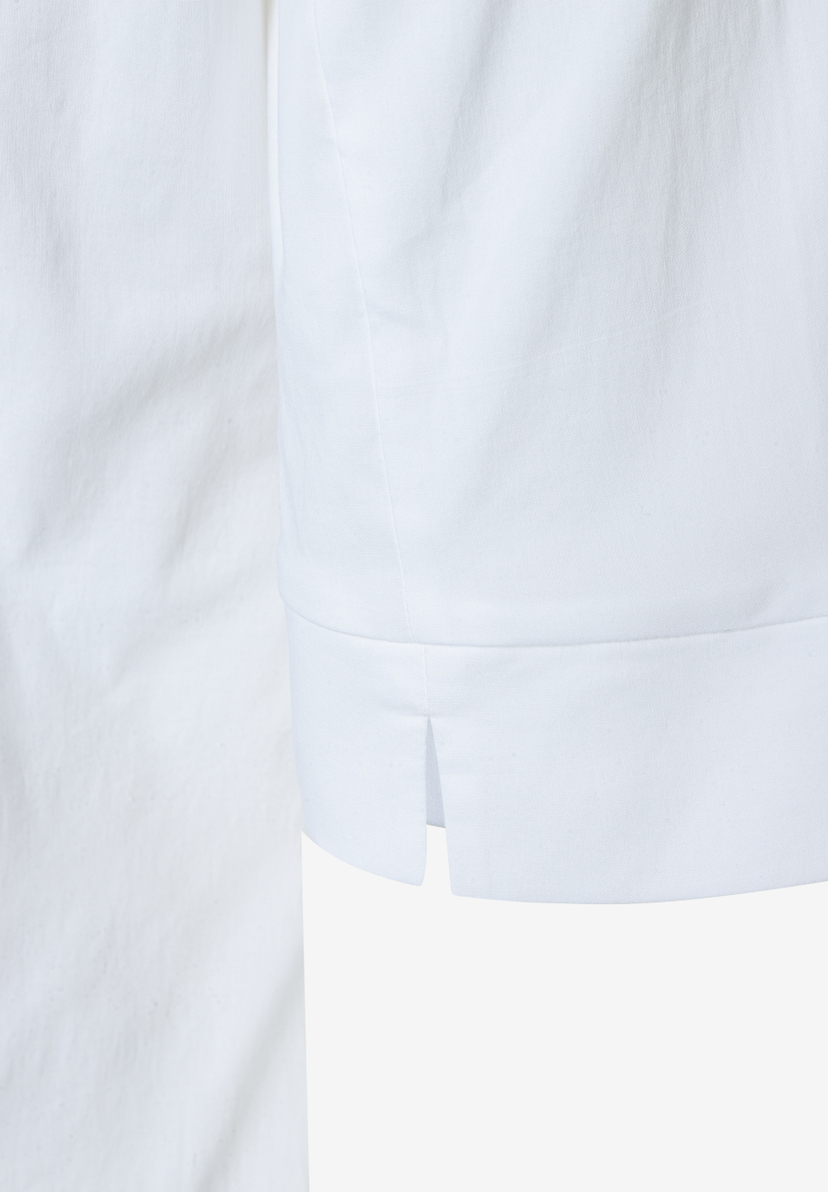 MORE & MORE Bluse aus weißem Popeline-Stoff, detailgetreue Ansicht des Saums mit seitlichem Schlitz. MORE & MORE Bluse aus weißem Popeline-Stoff, detailgetreue Ansicht des Saums mit seitlichem Schlitz.