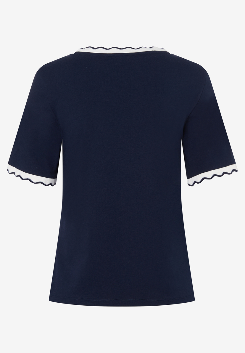 Ein dunkelblaues MORE & MORE Oberteil mit weißen, gewellten Abschlüssen an Kragen und Ärmeln. Ein dunkelblaues MORE & MORE Oberteil mit weißen, gewellten Abschlüssen an Kragen und Ärmeln.