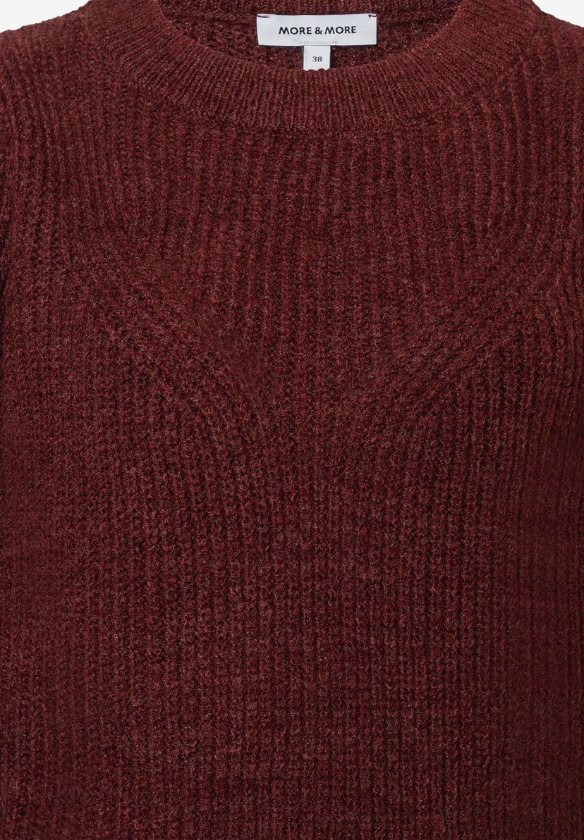Nahaufnahme eines bordeauxroten MORE & MORE Strickpullovers mit Rundhalsausschnitt und Rippstrickmuster. Nahaufnahme eines bordeauxroten MORE & MORE Strickpullovers mit Rundhalsausschnitt und Rippstrickmuster.