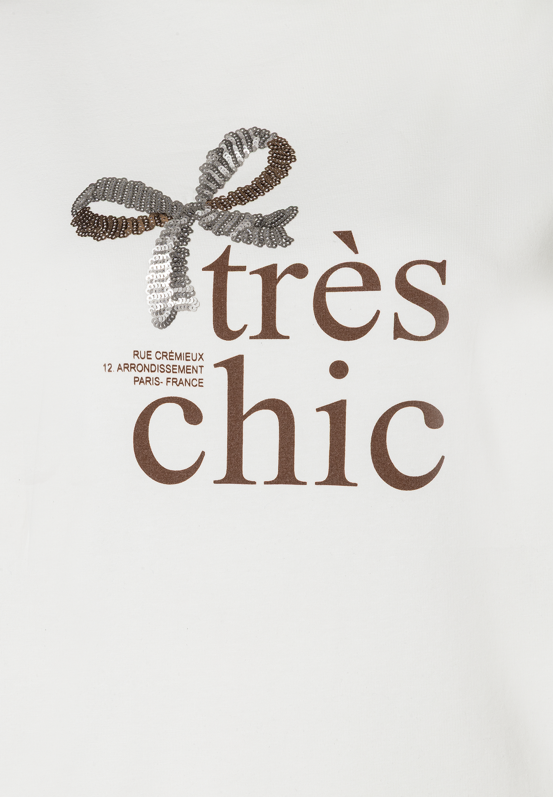 Ein MORE & MORE Oberteil mit einer Schleife und dem Schriftzug „très chic“. Ein MORE & MORE Oberteil mit einer Schleife und dem Schriftzug „très chic“.