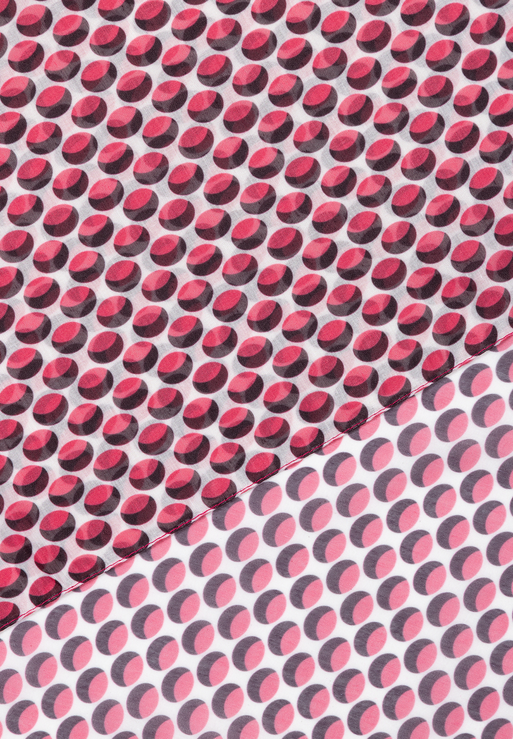 Detailaufnahme eines Accessoires von MORE & MORE mit einem Muster aus roten und rosa Punkten auf weißem Stoff. Detailaufnahme eines Accessoires von MORE & MORE mit einem Muster aus roten und rosa Punkten auf weißem Stoff.