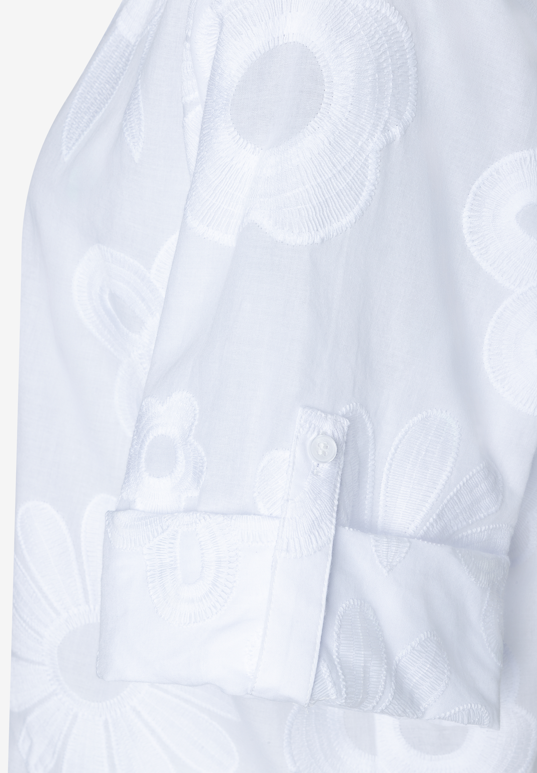 Nahaufnahme einer weißen MORE & MORE Bluse mit floralen Stickereien und Knopf am Ärmel. Nahaufnahme einer weißen MORE & MORE Bluse mit floralen Stickereien und Knopf am Ärmel.