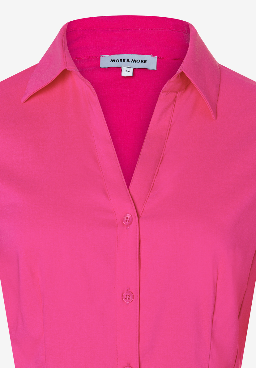 Nahaufnahme einer pinken MORE & MORE Bluse mit Kragen und Knopfleiste. Nahaufnahme einer pinken MORE & MORE Bluse mit Kragen und Knopfleiste.