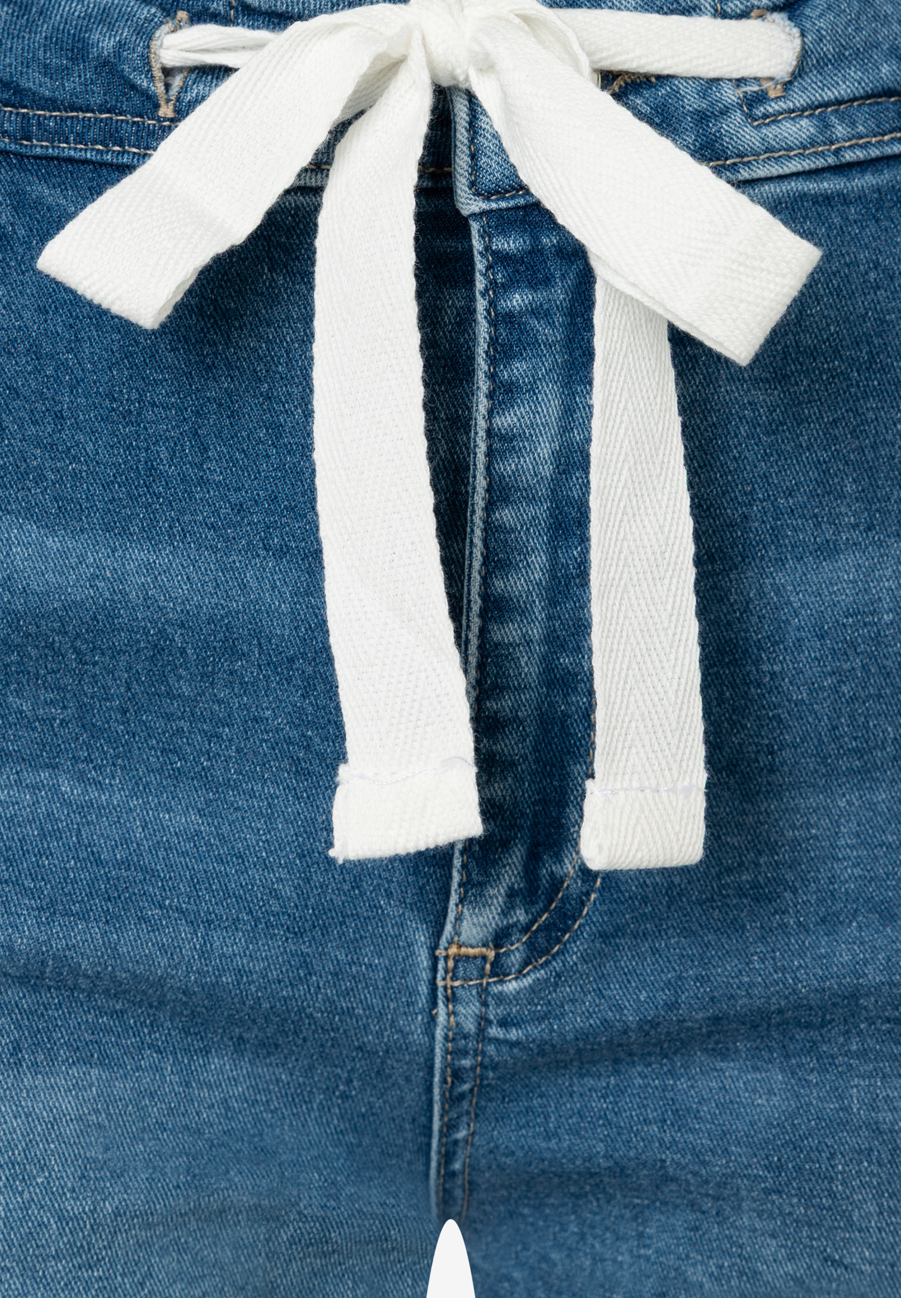 Nahaufnahme einer MORE & MORE Jeanshose mit weißem Kordelzug und elastischem Denim-Material. Nahaufnahme einer MORE & MORE Jeanshose mit weißem Kordelzug und elastischem Denim-Material.