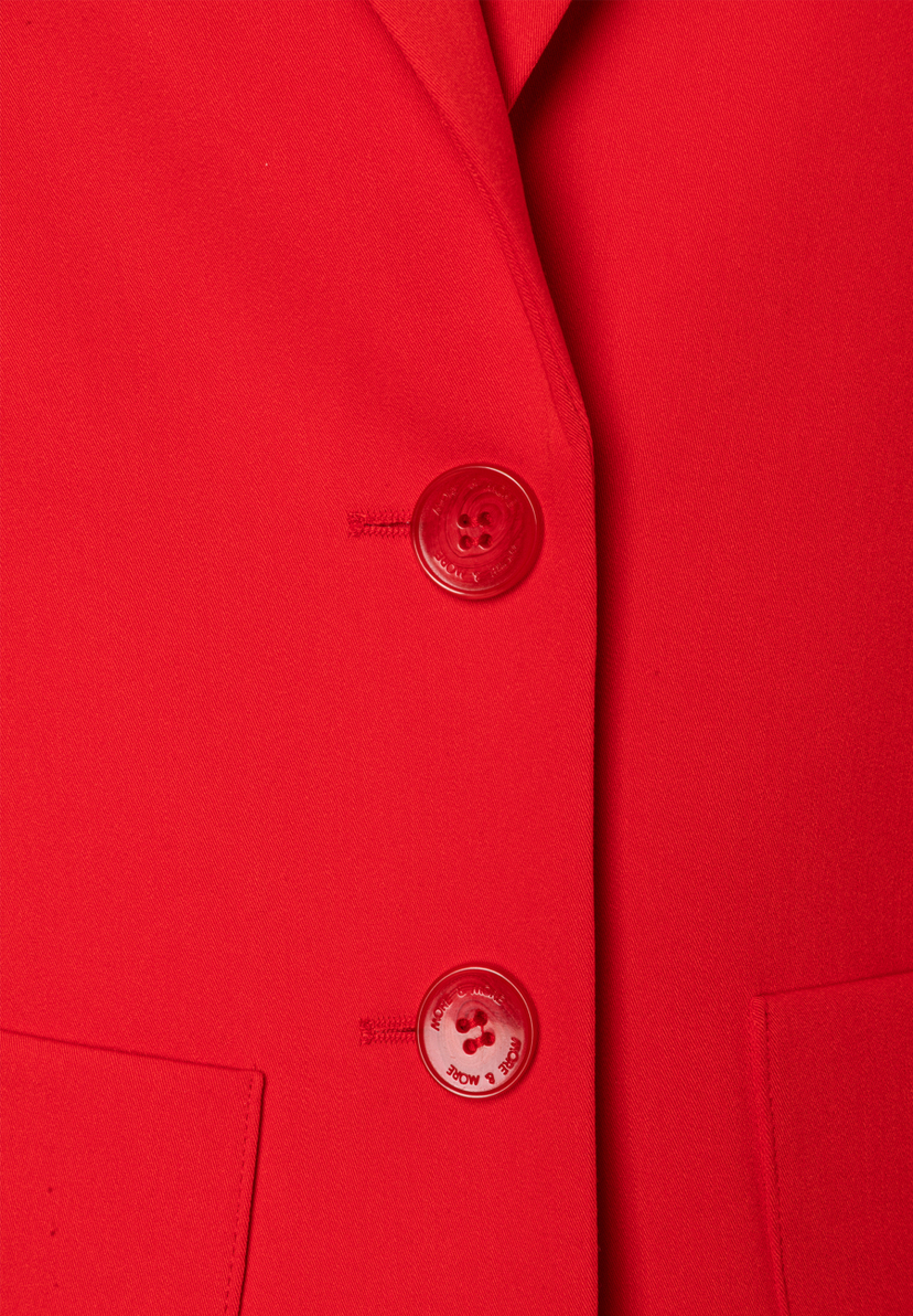 Nahaufnahme eines roten MORE & MORE Blazers mit zwei Knöpfen und einer kleinen Tasche. Nahaufnahme eines roten MORE & MORE Blazers mit zwei Knöpfen und einer kleinen Tasche.