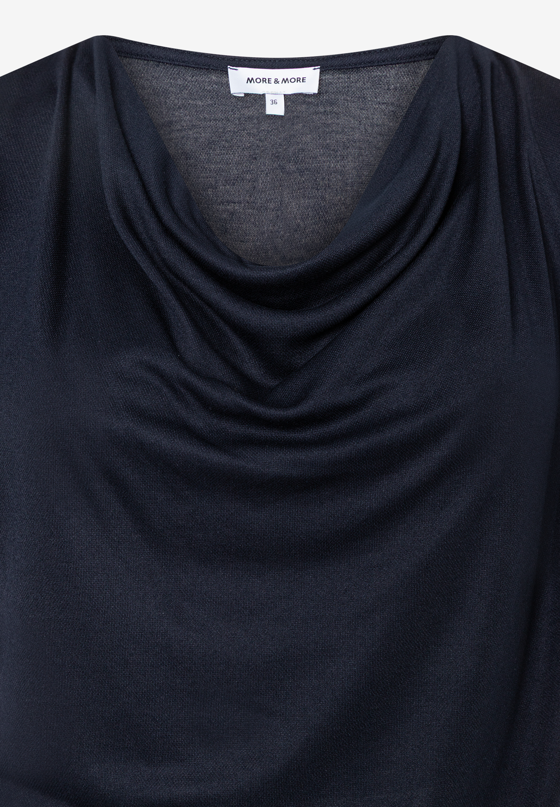 Nahaufnahme eines dunkelblauen MORE & MORE Oberteils mit Wasserfallkragen. Nahaufnahme eines dunkelblauen MORE & MORE Oberteils mit Wasserfallkragen.