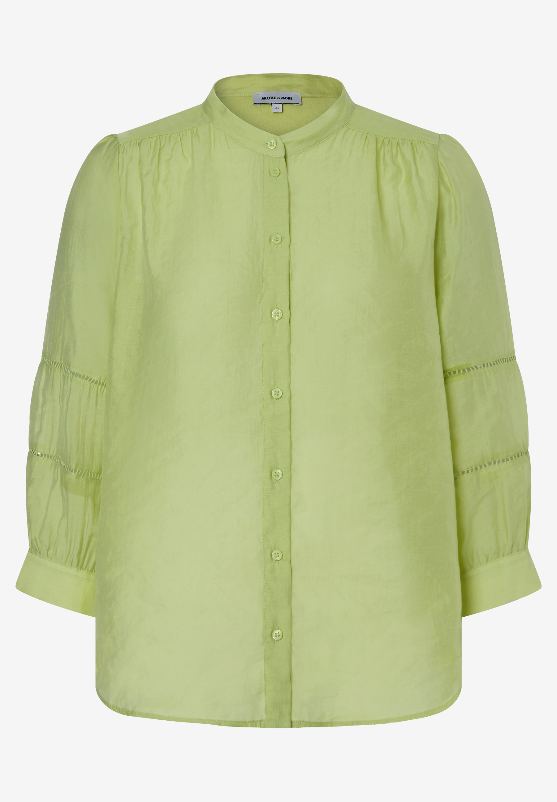 Eine hellgrüne, leicht transparente Bluse von MORE & MORE mit langen Ärmeln und Knopfleiste. Eine hellgrüne, leicht transparente Bluse von MORE & MORE mit langen Ärmeln und Knopfleiste.