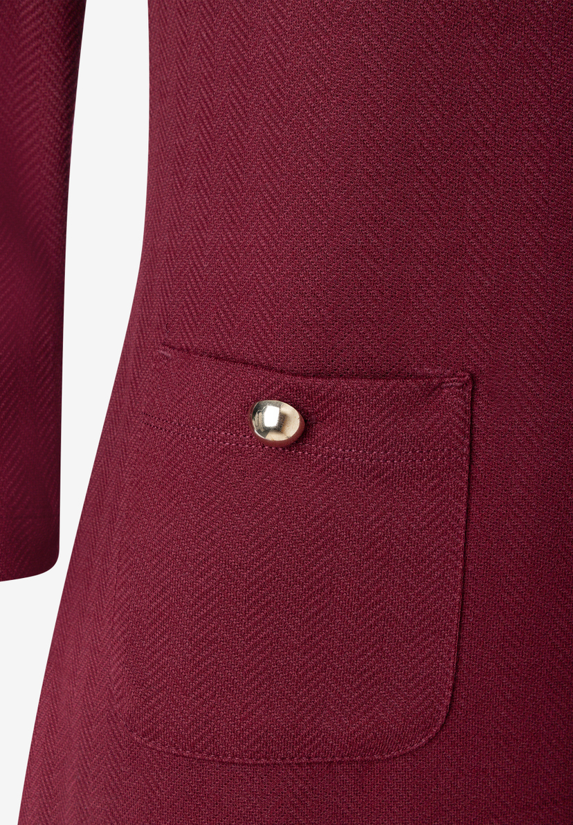 MORE & MORE Kleid: Nahaufnahme eines bordeauxroten Kleides mit Fischgrätmuster und einer goldfarbenen Taste auf der Tasche. MORE & MORE Kleid: Nahaufnahme eines bordeauxroten Kleides mit Fischgrätmuster und einer goldfarbenen Taste auf der Tasche.