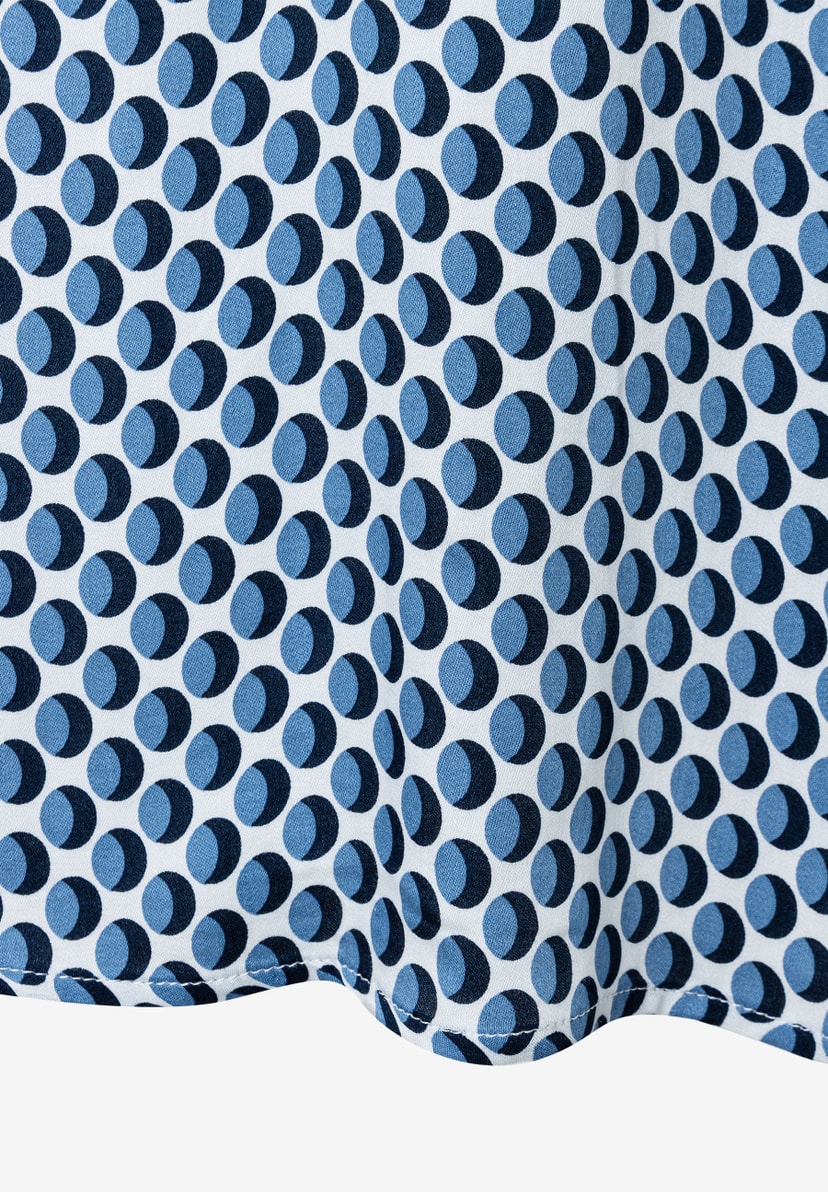 Nahaufnahme einer MORE & MORE Bluse mit blauem Punktmuster auf weißem Grund. Nahaufnahme einer MORE & MORE Bluse mit blauem Punktmuster auf weißem Grund.