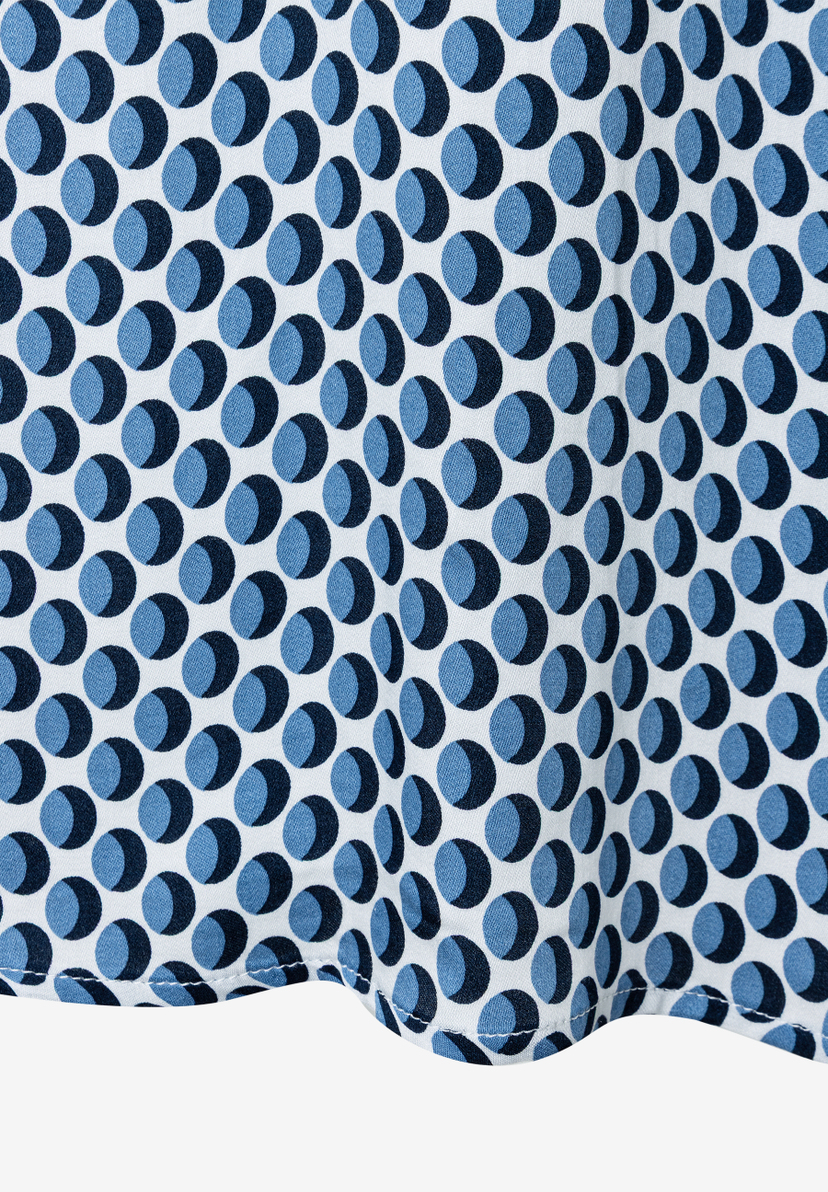 Nahaufnahme einer MORE & MORE Bluse mit blauem Punktmuster auf weißem Grund. Nahaufnahme einer MORE & MORE Bluse mit blauem Punktmuster auf weißem Grund.