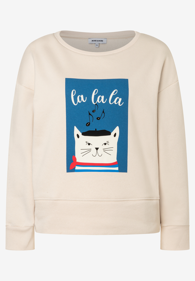 Ein beigefarbenes MORE & MORE Sweatshirt mit einer Katze mit Baskenmütze und Noten-Motiv. Ein beigefarbenes MORE & MORE Sweatshirt mit einer Katze mit Baskenmütze und Noten-Motiv.