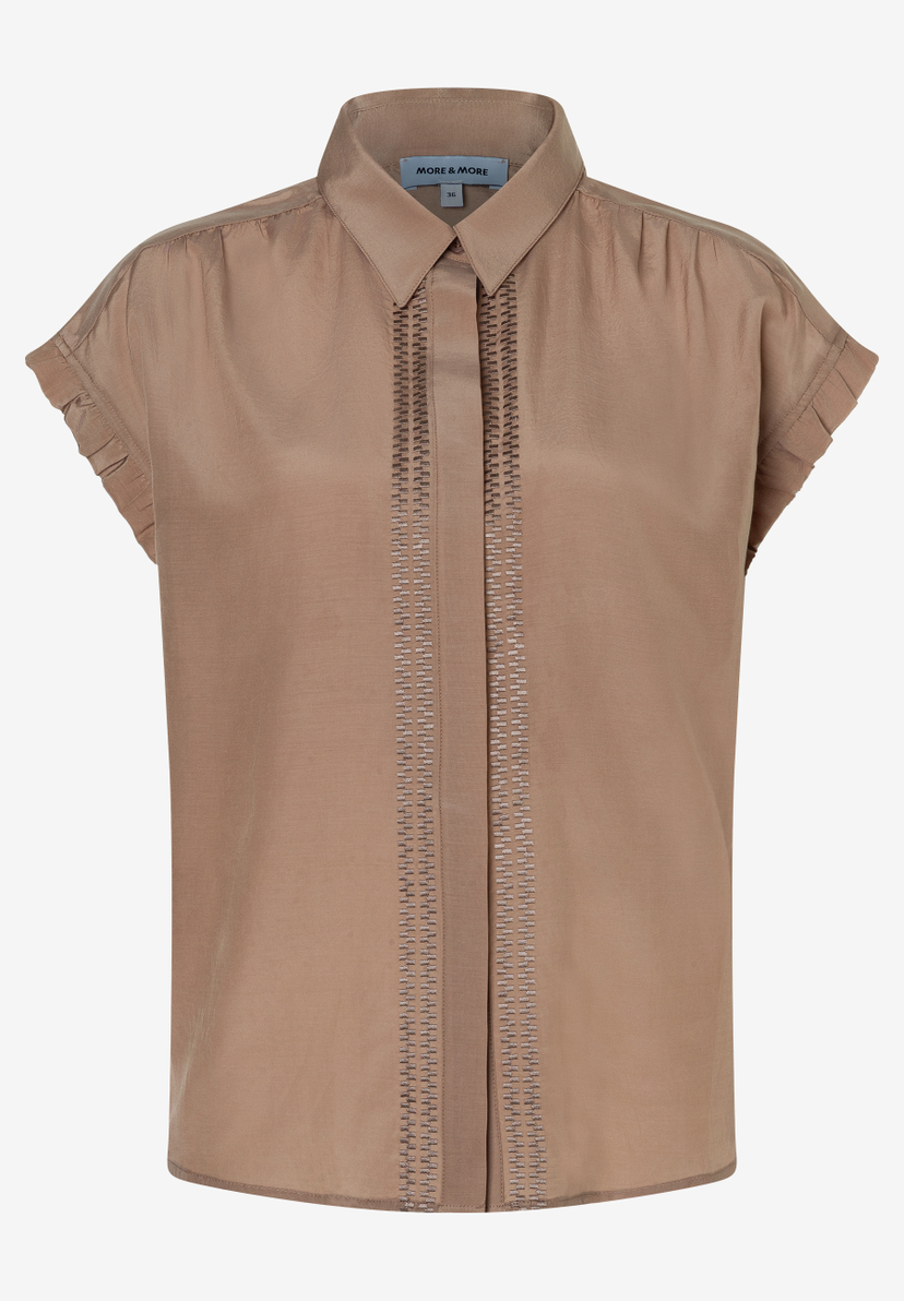 Eine hellbraune Bluse von MORE & MORE mit kurzen Ärmeln und einer dekorativen Borten-Applikation. Eine hellbraune Bluse von MORE & MORE mit kurzen Ärmeln und einer dekorativen Borten-Applikation.
