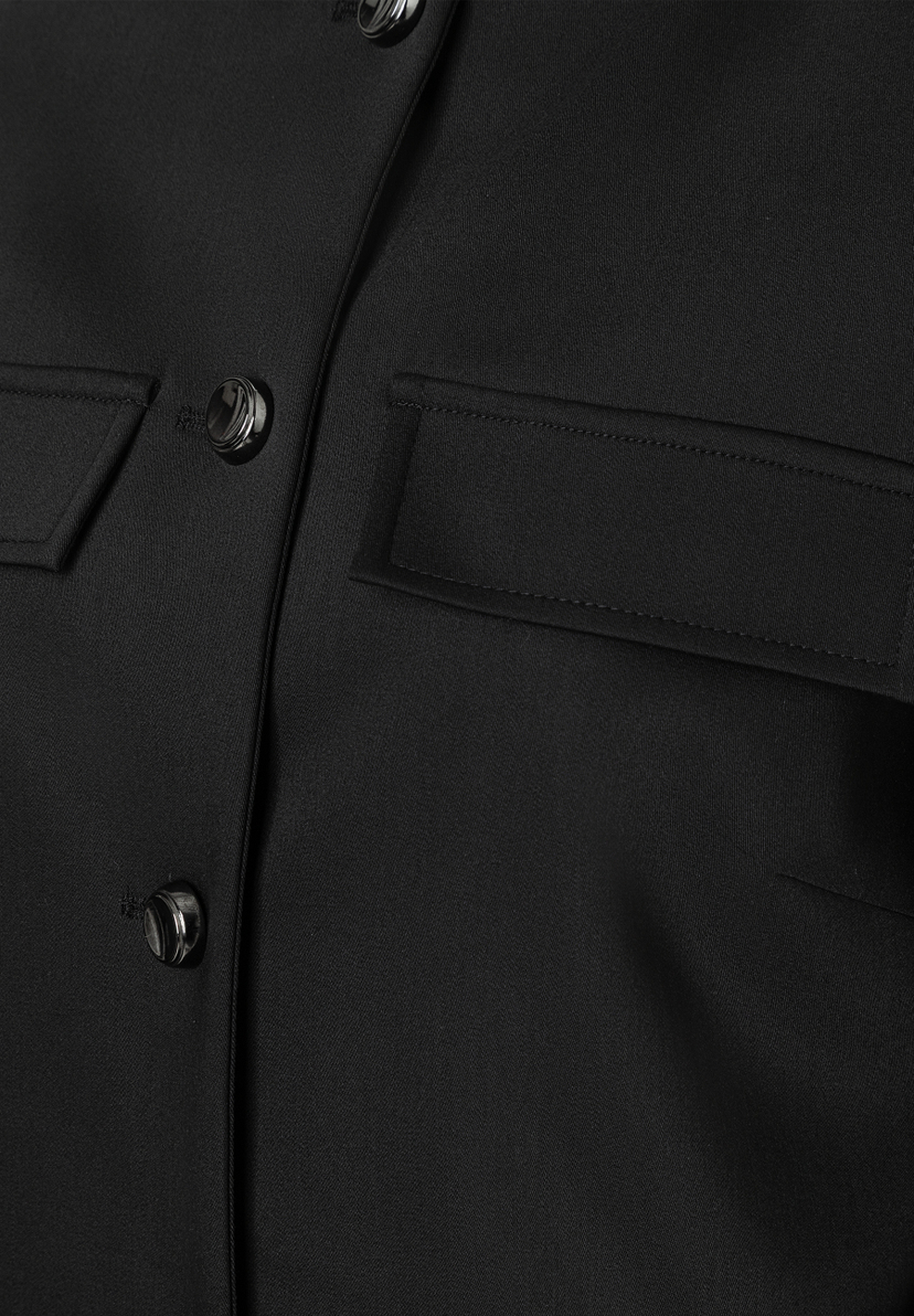 Nahaufnahme eines schwarzen MORE & MORE Blazers mit Knöpfen und einer Tasche. Nahaufnahme eines schwarzen MORE & MORE Blazers mit Knöpfen und einer Tasche.