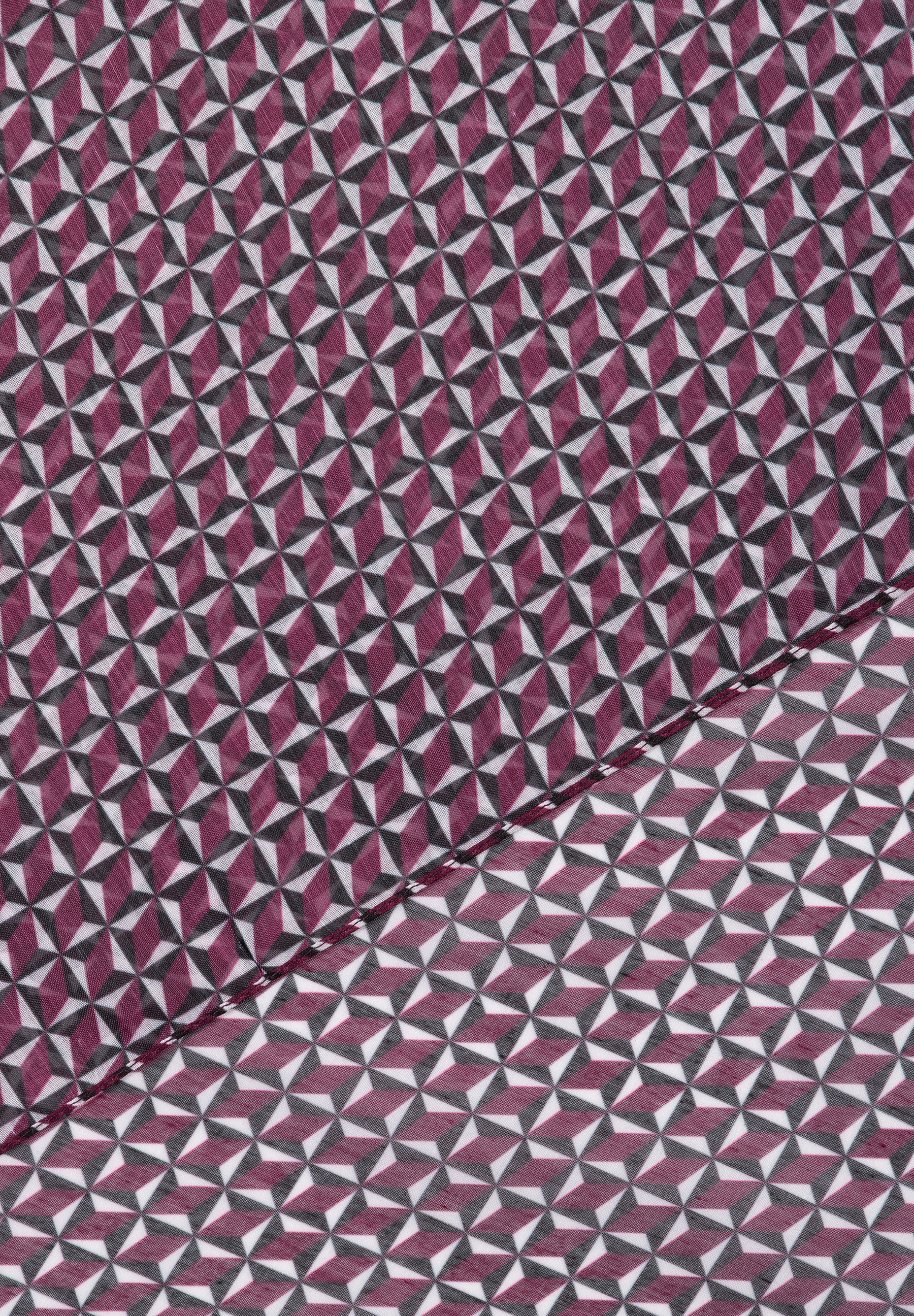 Nahaufnahme eines MORE & MORE Accessoires mit geometrischem Muster in Weiß, Burgunderrot und Schwarz. Nahaufnahme eines MORE & MORE Accessoires mit geometrischem Muster in Weiß, Burgunderrot und Schwarz.