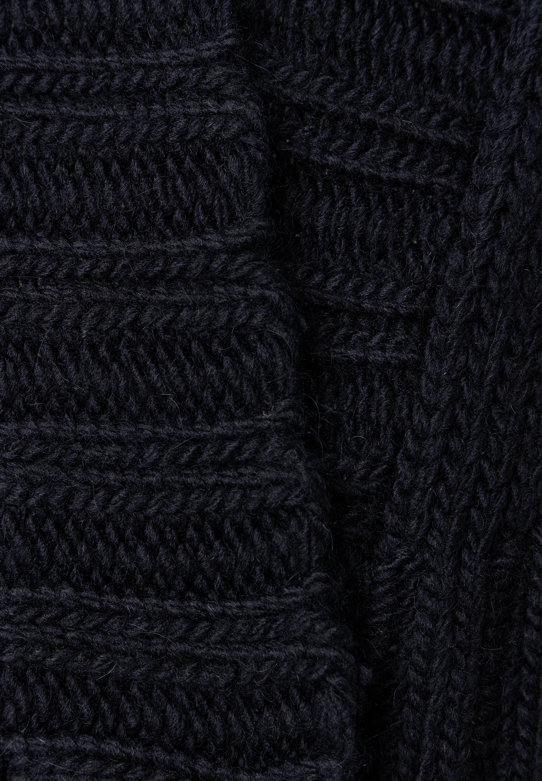 MORE & MORE Pullover: Nahaufnahme des dunkelblauen Zopfstrickmusters, das die detaillierte Textur zeigt. MORE & MORE Pullover: Nahaufnahme des dunkelblauen Zopfstrickmusters, das die detaillierte Textur zeigt.