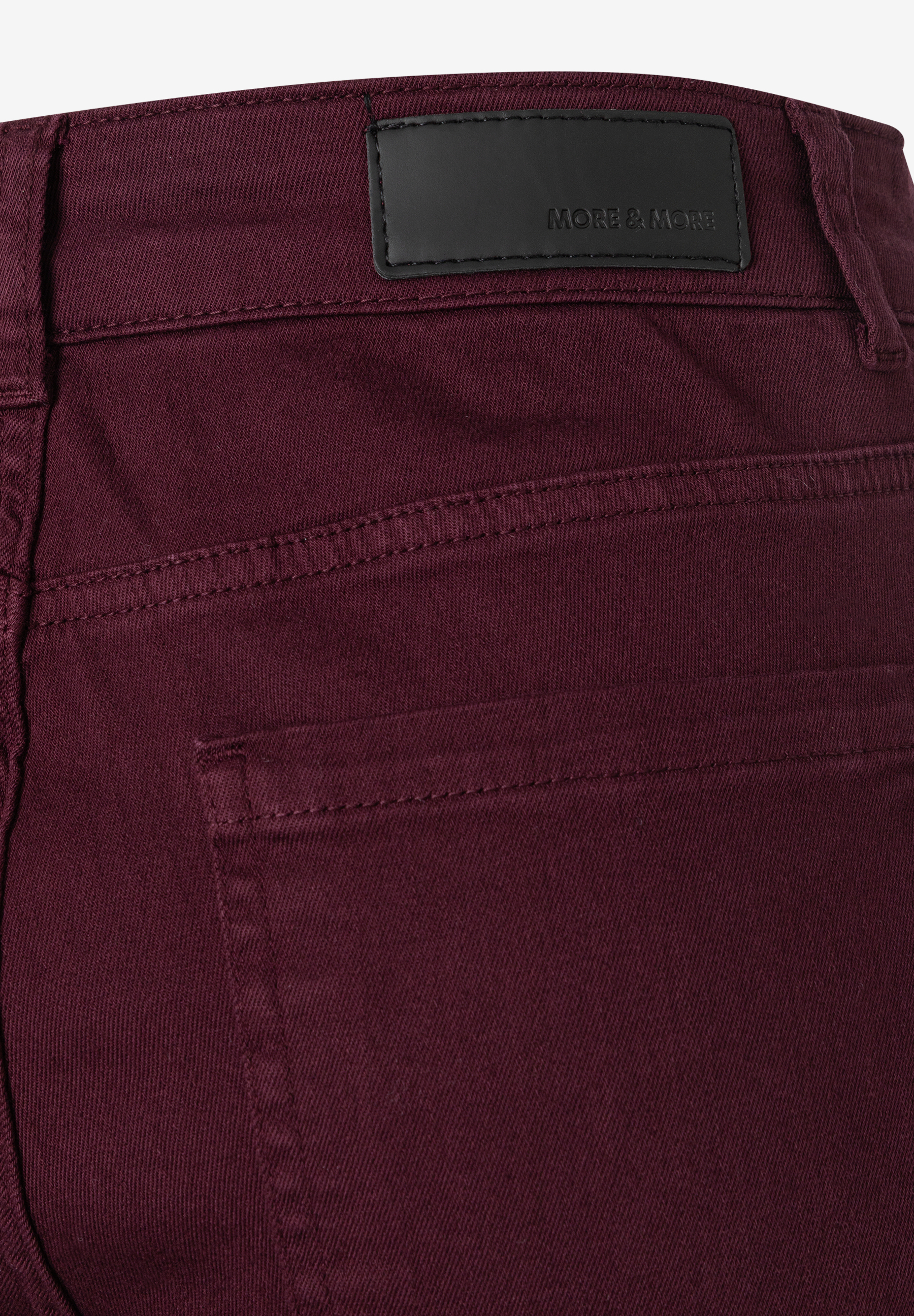 MORE & MORE Jeans: Rückseite einer bordeauxroten Jeans, mit schwarzem Label und Gesäßtasche. MORE & MORE Jeans: Rückseite einer bordeauxroten Jeans, mit schwarzem Label und Gesäßtasche.