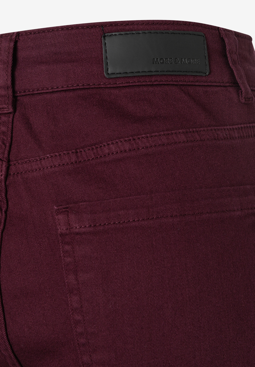 MORE & MORE Jeans: Rückseite einer bordeauxroten Jeans, mit schwarzem Label und Gesäßtasche. MORE & MORE Jeans: Rückseite einer bordeauxroten Jeans, mit schwarzem Label und Gesäßtasche.