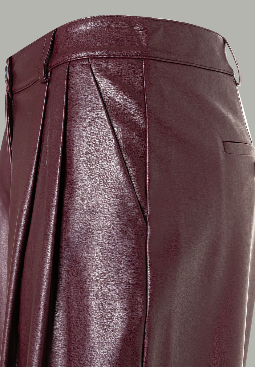 Nahaufnahme einer MORE & MORE Hose/Jeans aus bordeauxrotem Kunstleder mit Bundfalten und seitlichen Eingrifftaschen.