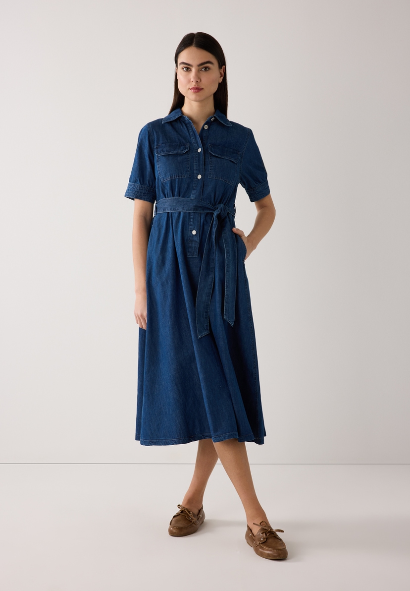 Eine Frau im MORE & MORE Jeans-Hemdkleid mit Gürtel und bequemer Denim-Konstruktion. Eine Frau im MORE & MORE Jeans-Hemdkleid mit Gürtel und bequemer Denim-Konstruktion.