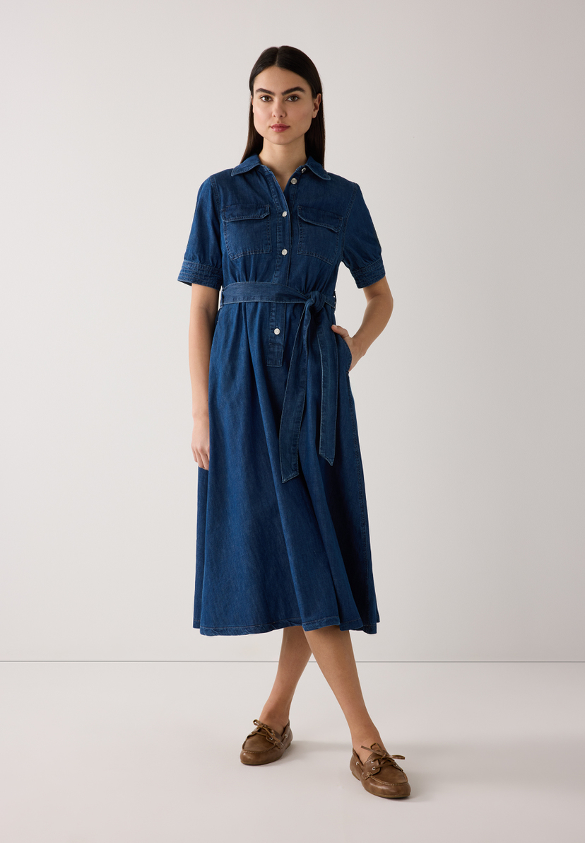 Eine Frau im MORE & MORE Jeans-Hemdkleid mit Gürtel und bequemer Denim-Konstruktion. Eine Frau im MORE & MORE Jeans-Hemdkleid mit Gürtel und bequemer Denim-Konstruktion.