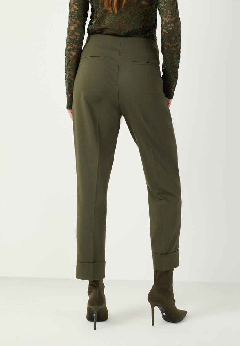 MORE & MORE Stoffhose in Khaki mit Umschlag und Abnähern, kombiniert mit dunkelgrünem Spitzenoberteil und Stiefeletten.