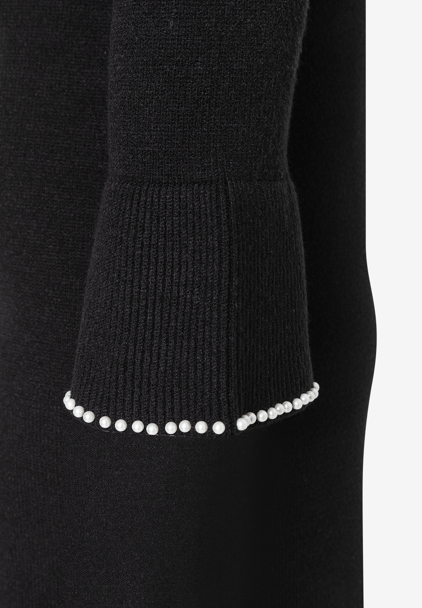 Ärmel eines schwarzen Strick-Oberteils von MORE & MORE mit Perlensaum. Ärmel eines schwarzen Strick-Oberteils von MORE & MORE mit Perlensaum.